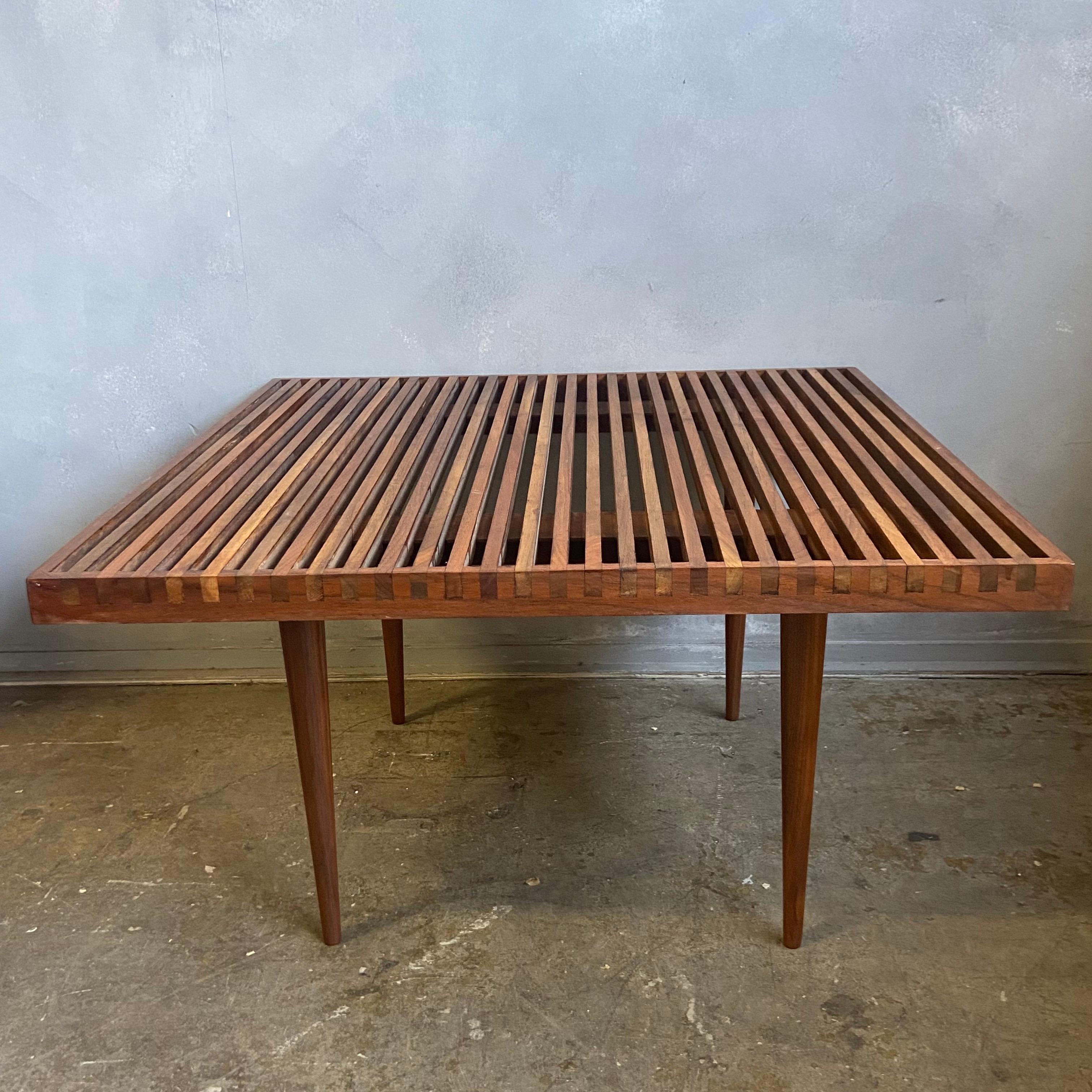 For your consideration is this beautiful walnut slat wood coffee table designed by Mel Smilow. Featuring wonderful dovetailed joinery on a square frame resting on tapered legs. A classic design that can function as a side table or coffee table.