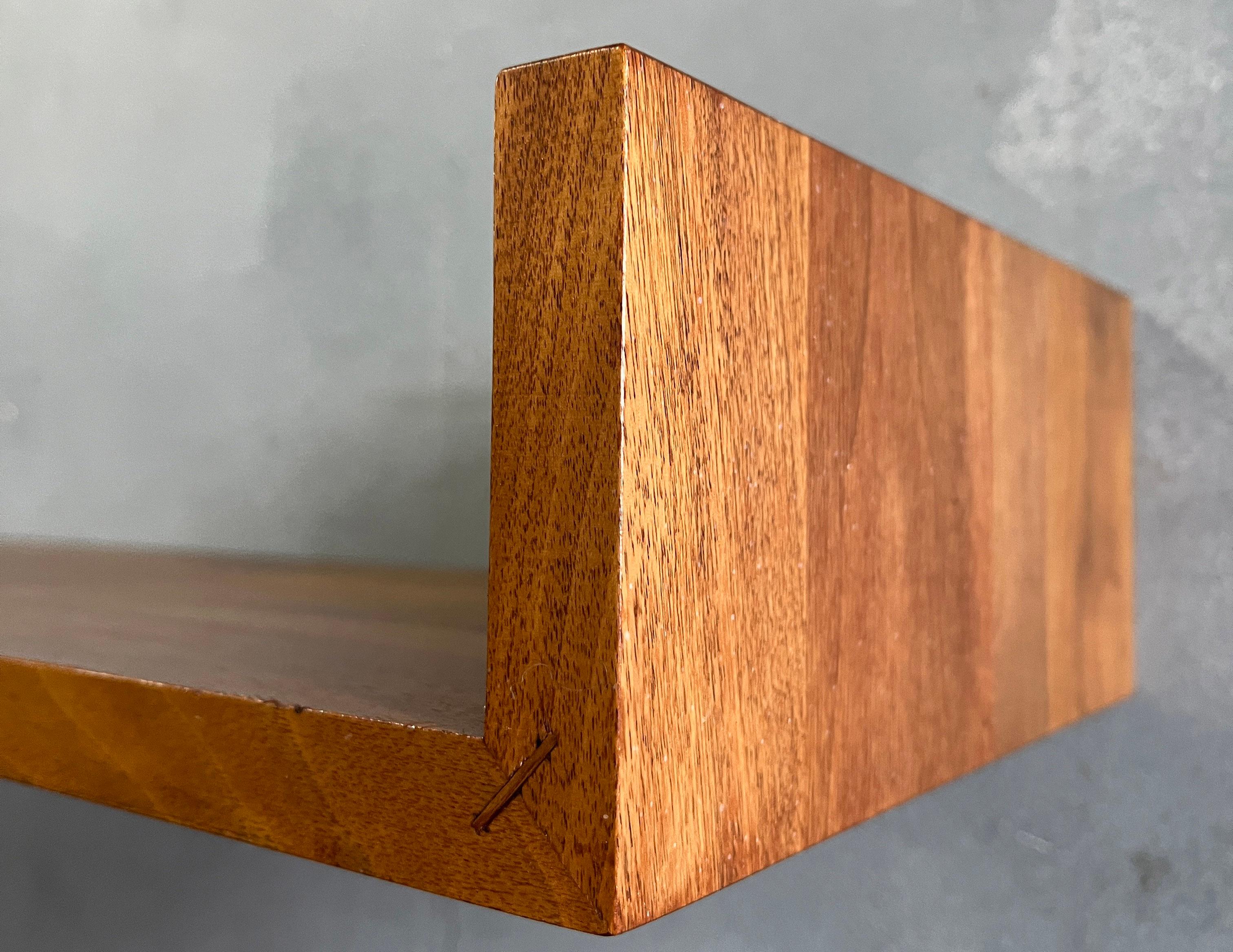For your consideration is this rare and beautiful walnut floating wall shelf designed by Mel Smilow. 
They connect to the wall with simple key hole hangers. The symmetry of the design help support the shelf against the wall firmly and strong. No