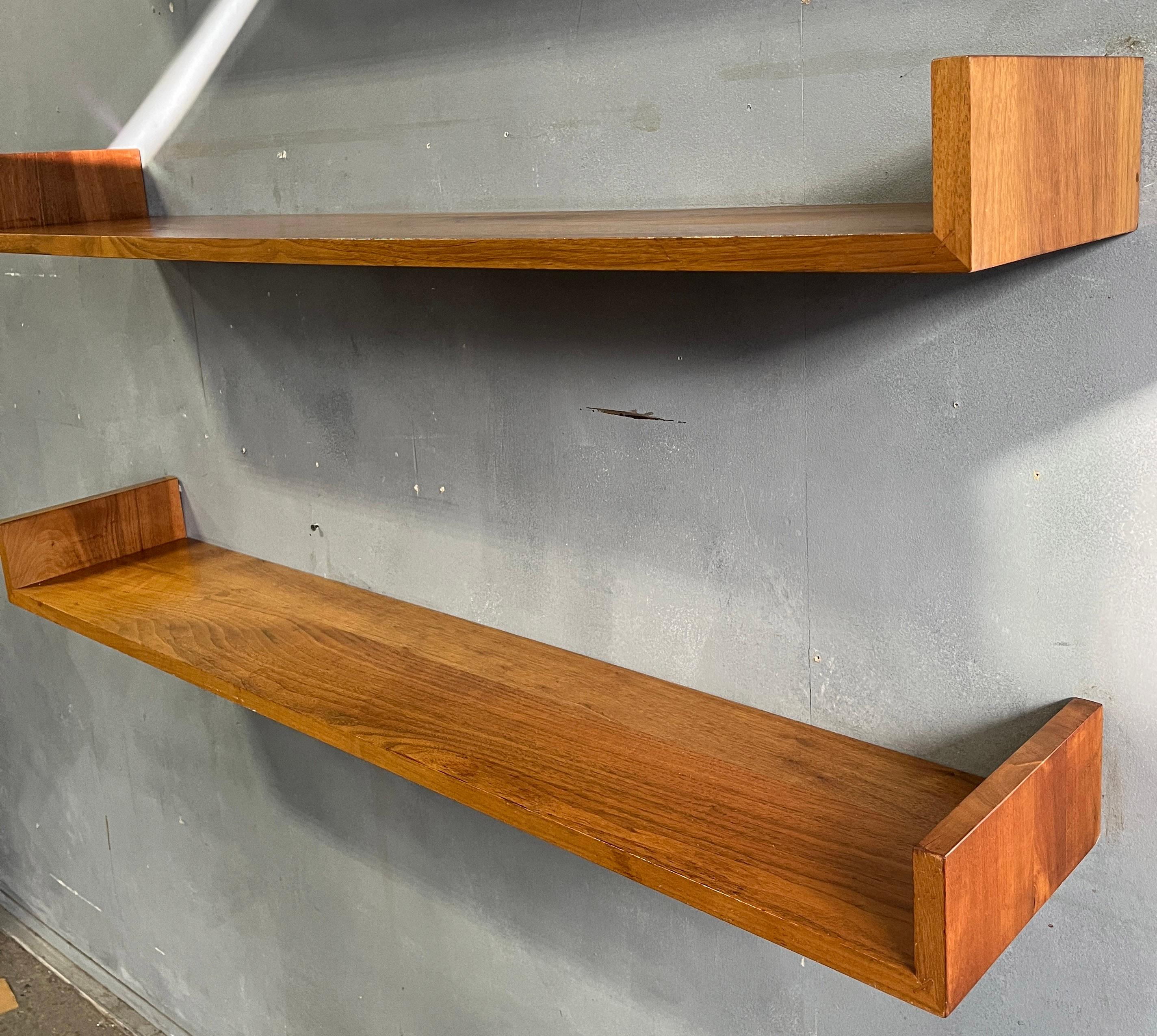 For your consideration is this rare and beautiful walnut floating wall shelf designed by Mel Smilow. They connect to the wall with simple key hole hangers. The symmetry of the design help support the shelf against the wall firmly and strong. No need