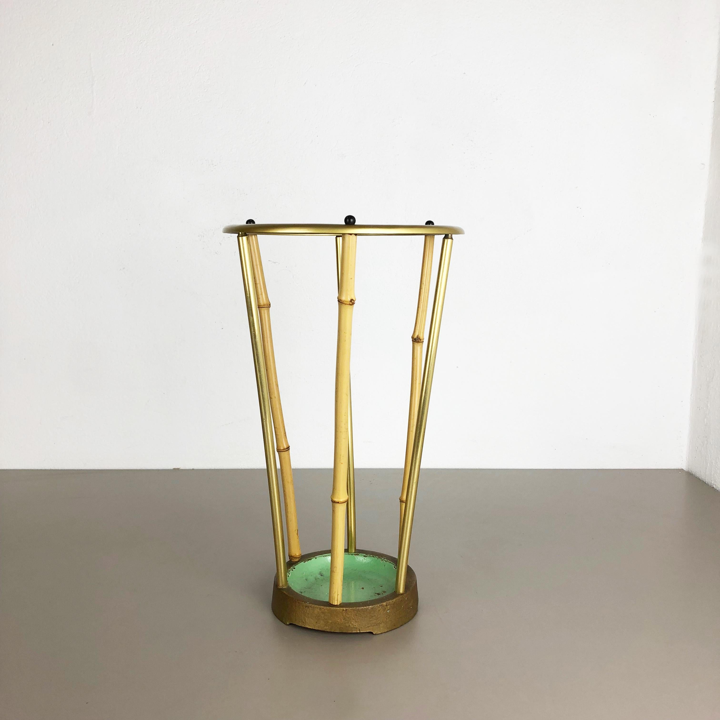 Article:

Midcentury umbrella stand


Origin:

Germany


Age:

1950s


This original vintage Bauhaus style umbrella stand was produced in the 1950s in Germany. It is made of metal with brass tone finishes upright stands and nice bamboo wood