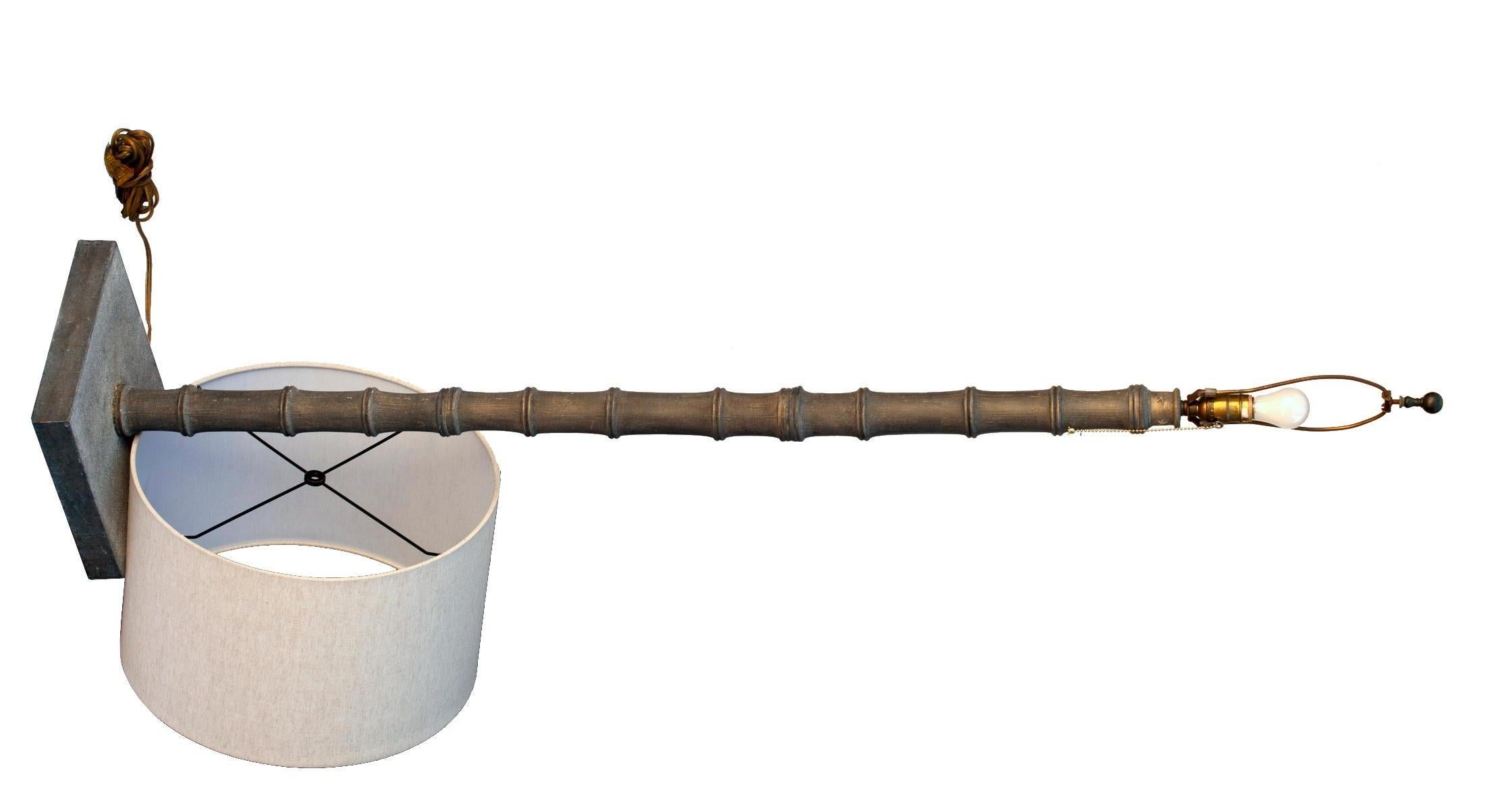 Des éléments métalliques empilés en finition bronze patiné suivent la forme du bambou. L'abat-jour, un nouveau tonneau en lin.
La base est surmontée d'une rangée d'étoiles à 5 branches entourant la rive supérieure empilée du 
