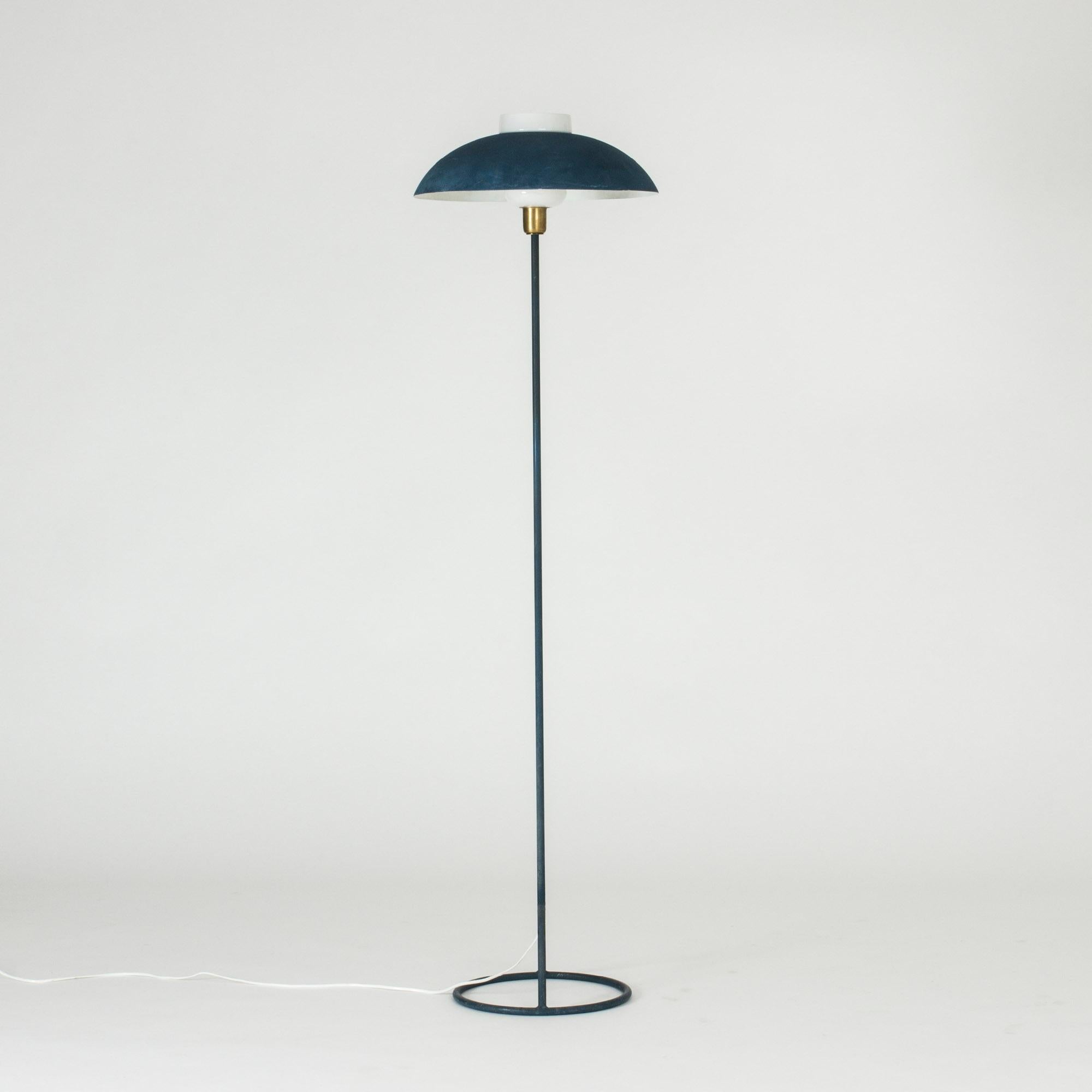 Striking metal floor lamp by Bertil Brisborg, with an exceptionally cool open space base. The lamp is lacquered blue in a grainy lacquer. Industrial, graphic design.