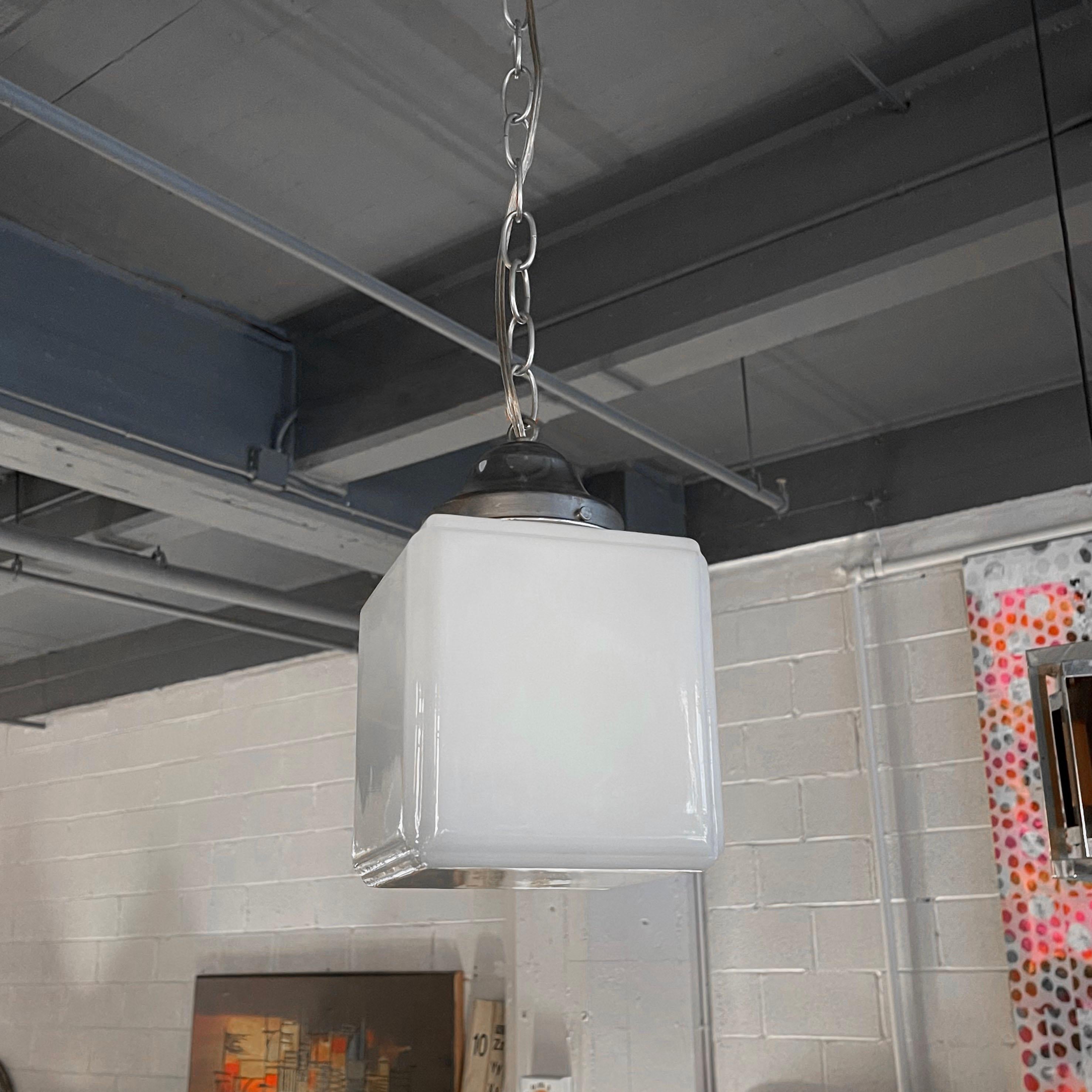 Midcentury pendant light features a 6 inch milk glass cube shade with aluminum fitter on 56 inches of steel chain link to hang at an overall height of 64 inches.