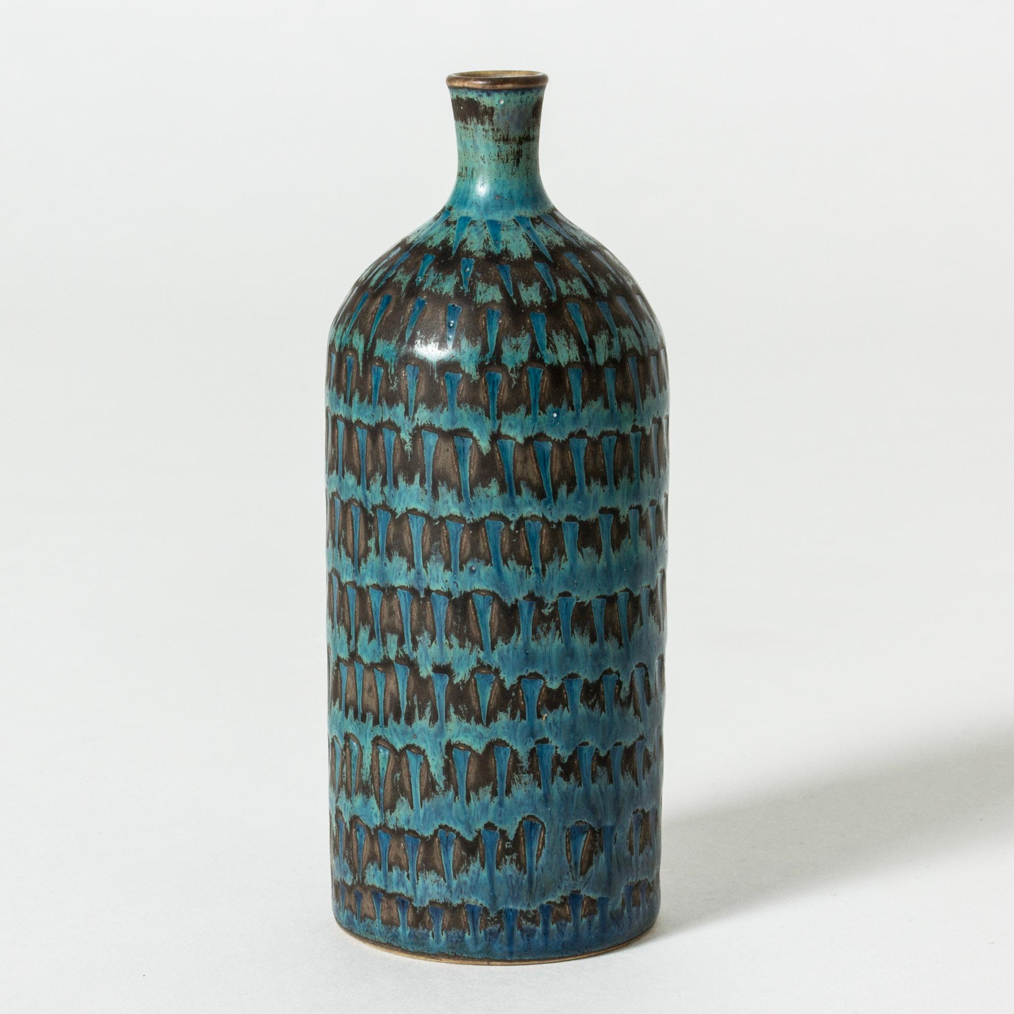 Cool stoneware vase by Stig Lindberg, in a cylinder form, more slender at the waist. Graphic pattern with greenish blue glaze.