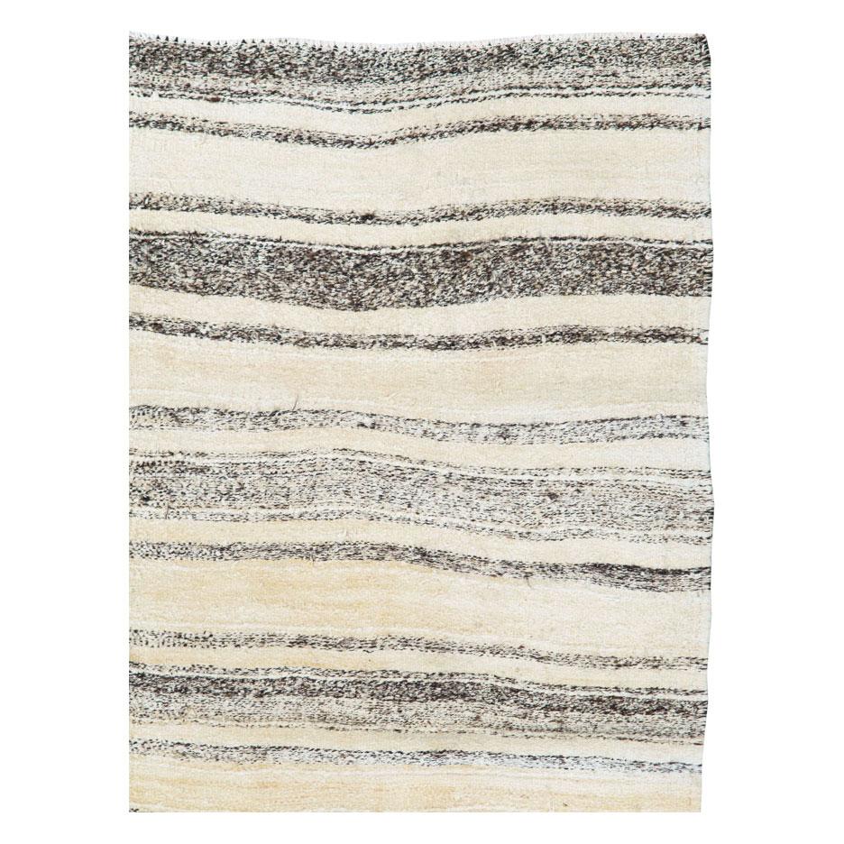 A vintage Persian flat-woven Kilim accent rug handmade during the mid-20th century using undyed wool in cream, ivory, and brown. The very neutral shades in earth tones, along with the simple striped pattern, creates a minimalistic effect that is