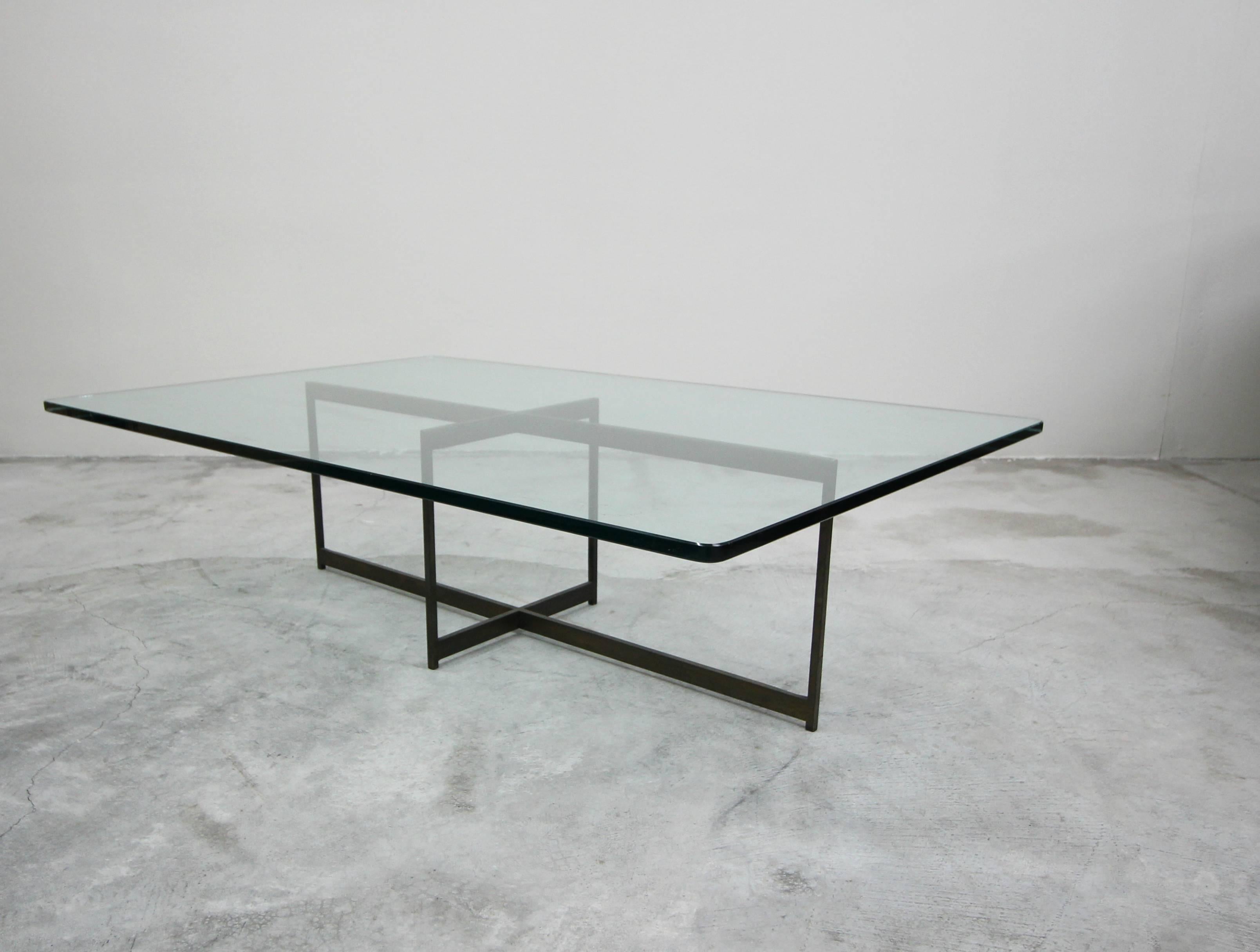 A beautiful midcentury bronze coffee table. Such a simple, yet modern and elegant piece. A minimalist bronze frame with a gorgeous piece of rectangular glass. 

Bronze has the most beautiful patina. Left as found, could be polished to bring it