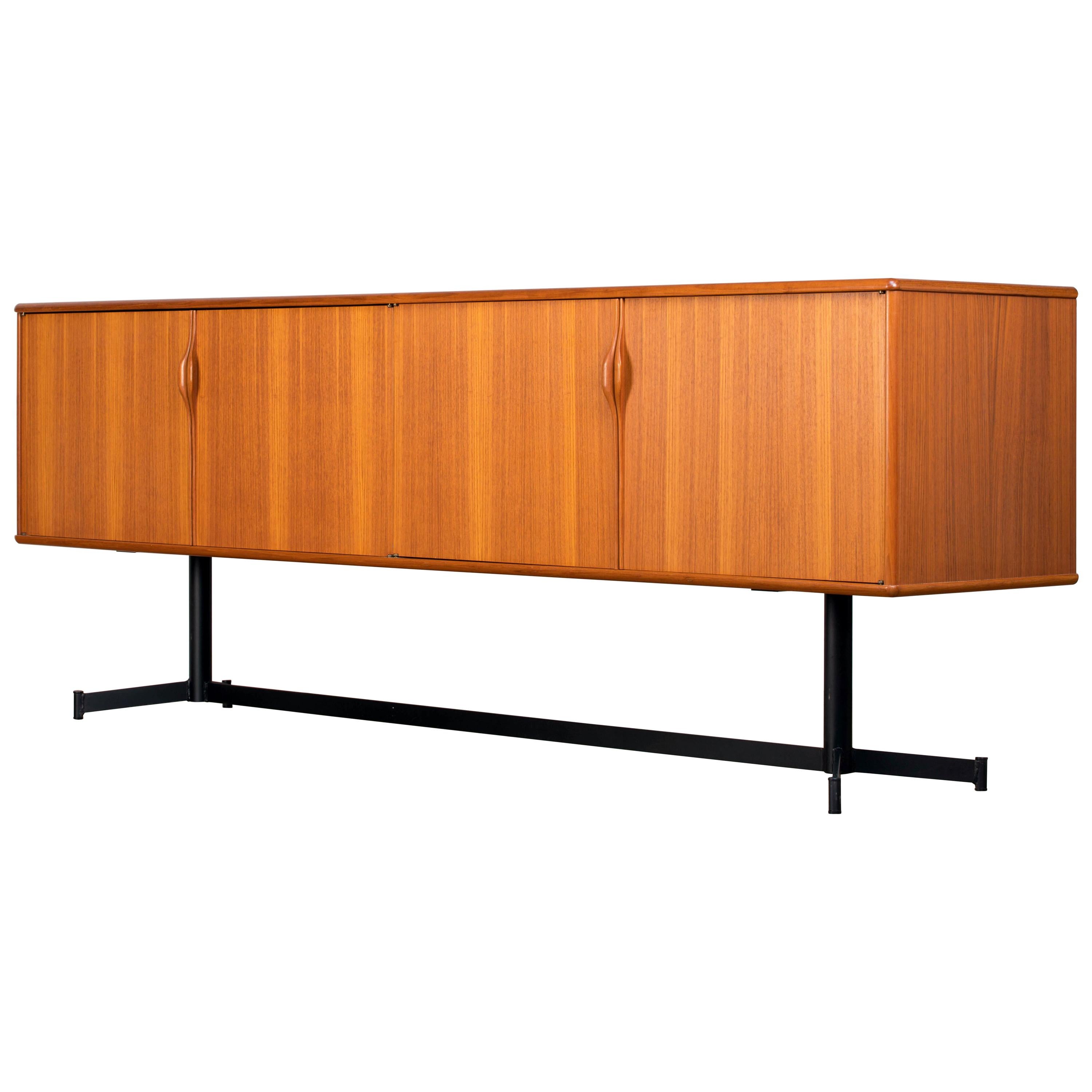 Midcentury teak sideboard from the 1960s. It is a shining example of the form and function synonymous with furniture of this era. It has is all, well-built, great design and heaviness. Four doors hiding storage space. The most remarkable aspect of