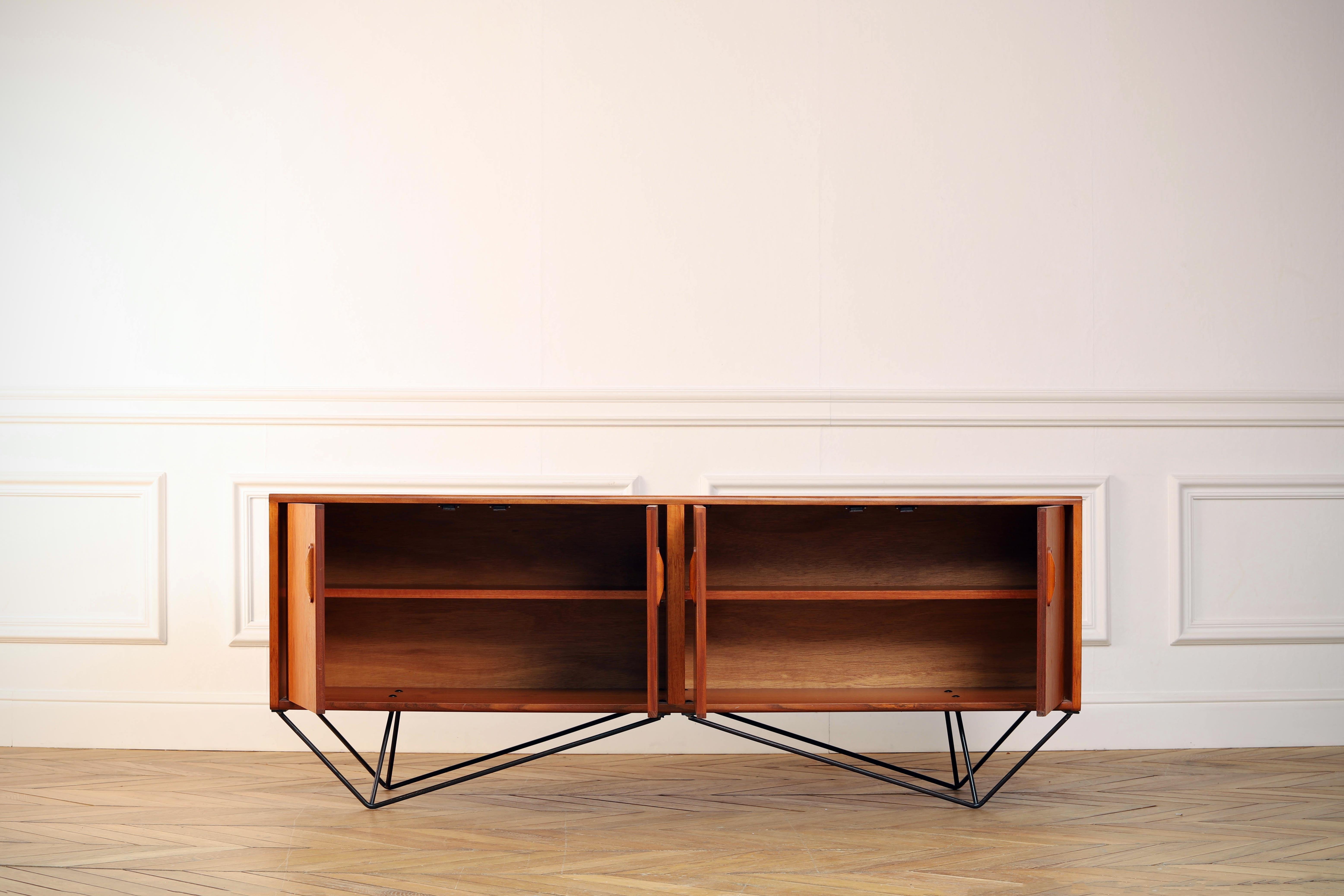 Midcentury teak sideboard from the 1960s. Stunning midcentury sideboard in teak, made in the 1960s. Beautiful minimal legs and carefully hollowed out discreet handles. The storage consists of two large sized cupboards.