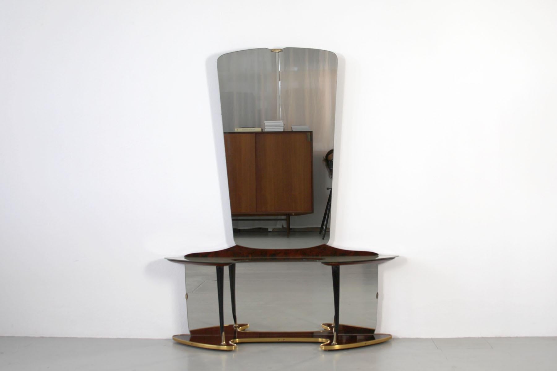 The vanity features a tapered vertical rectangular mirror on the top and a horizontal rectangular mirror in the bottom part of the piece. The console is shaped in an open curve which is also mirrored in shape by the bottom of the base. Additionally