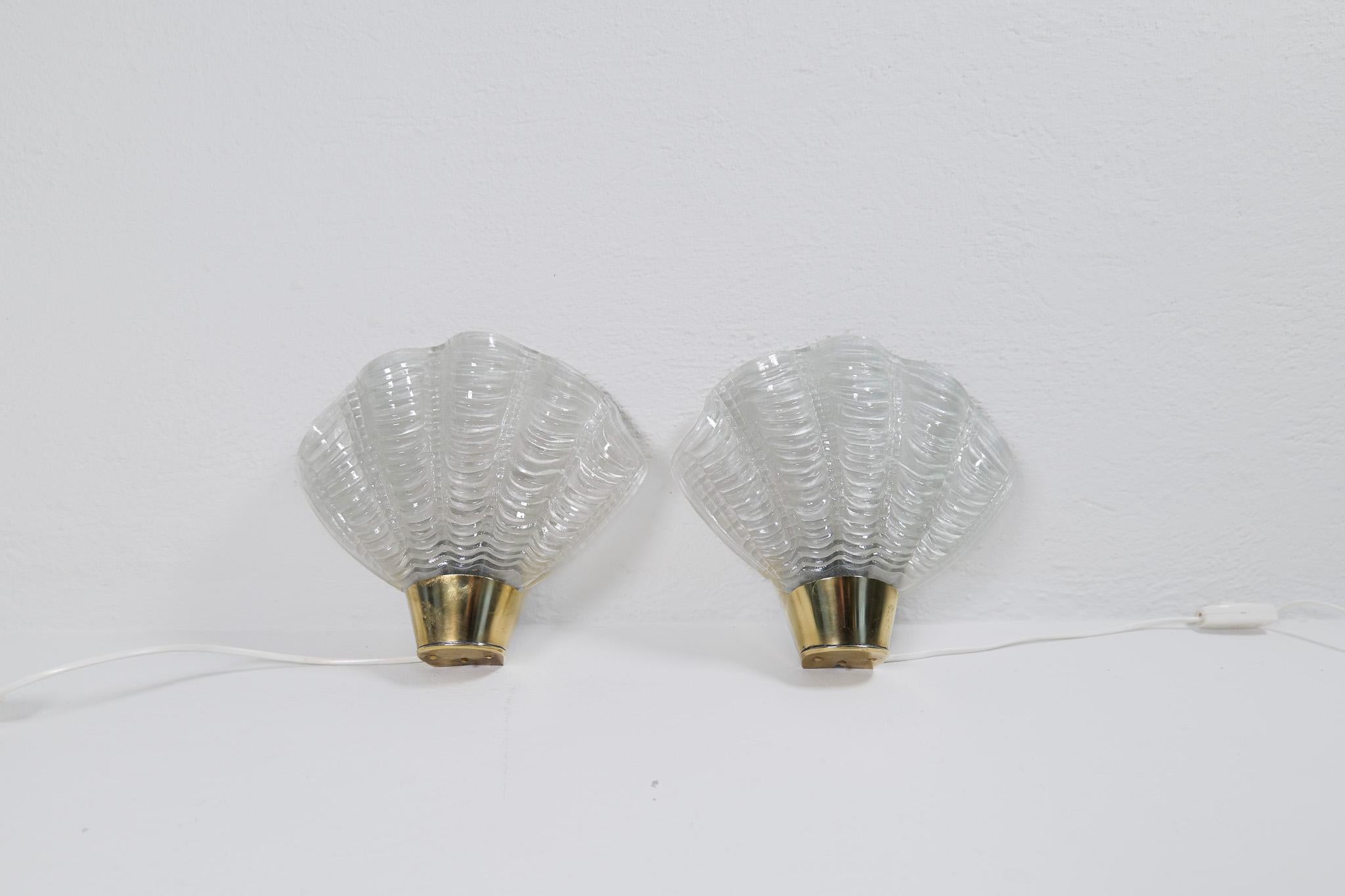This pair of wall lights in brass and glass were produced by ASEA, Sweden, 1950s. The glass made to look like seashells is great look and with the brass details it’s a stunning icon of a wall lamp. Can be hardwired or plugged in.

Good vintage