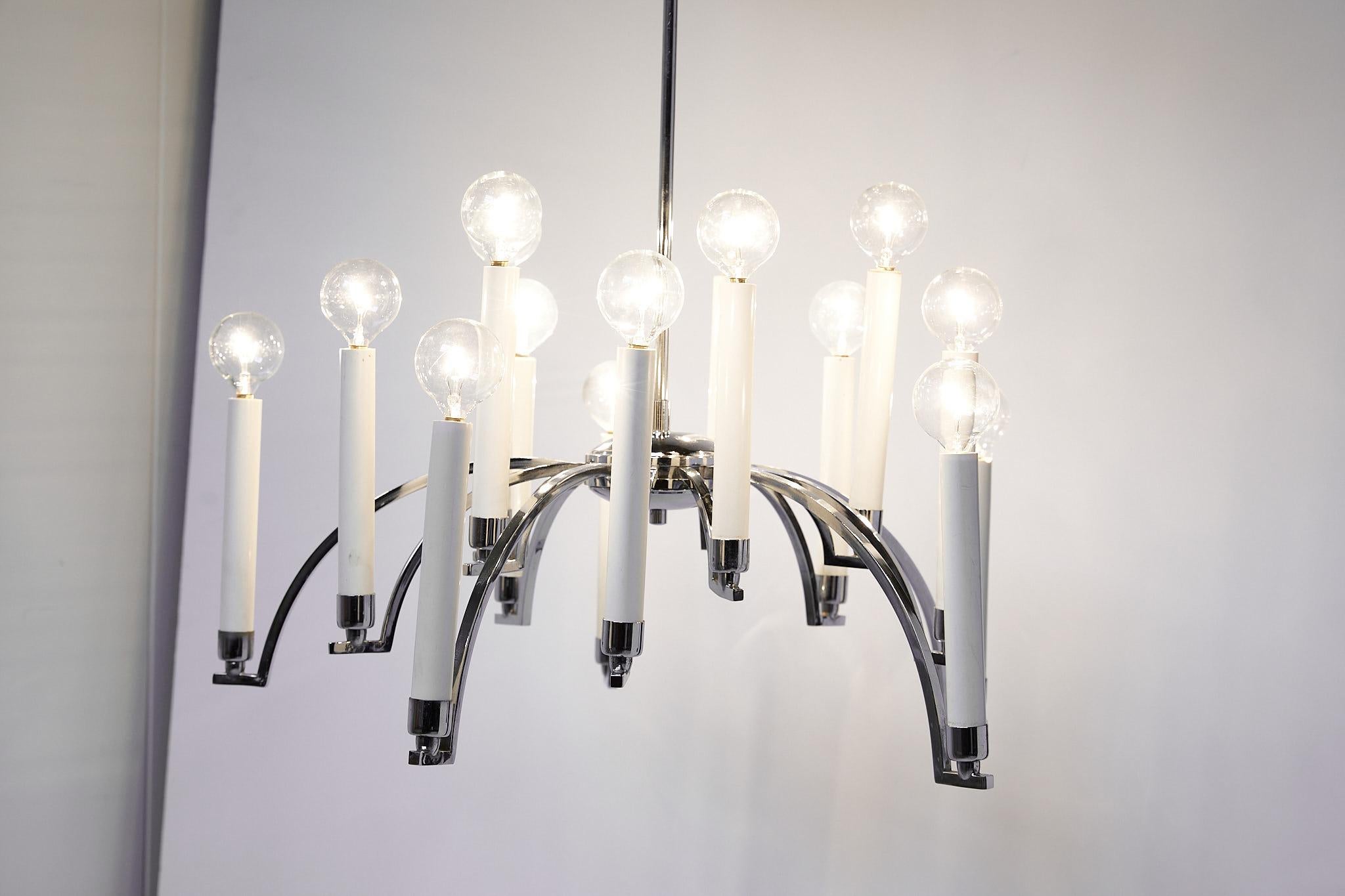 Mid-20th century chandelier made of chrome with 14 downswept arms supporting modern candlesticks holding chandelier bulbs. The chandelier was manufactured in the 1970s by Lightolier.
