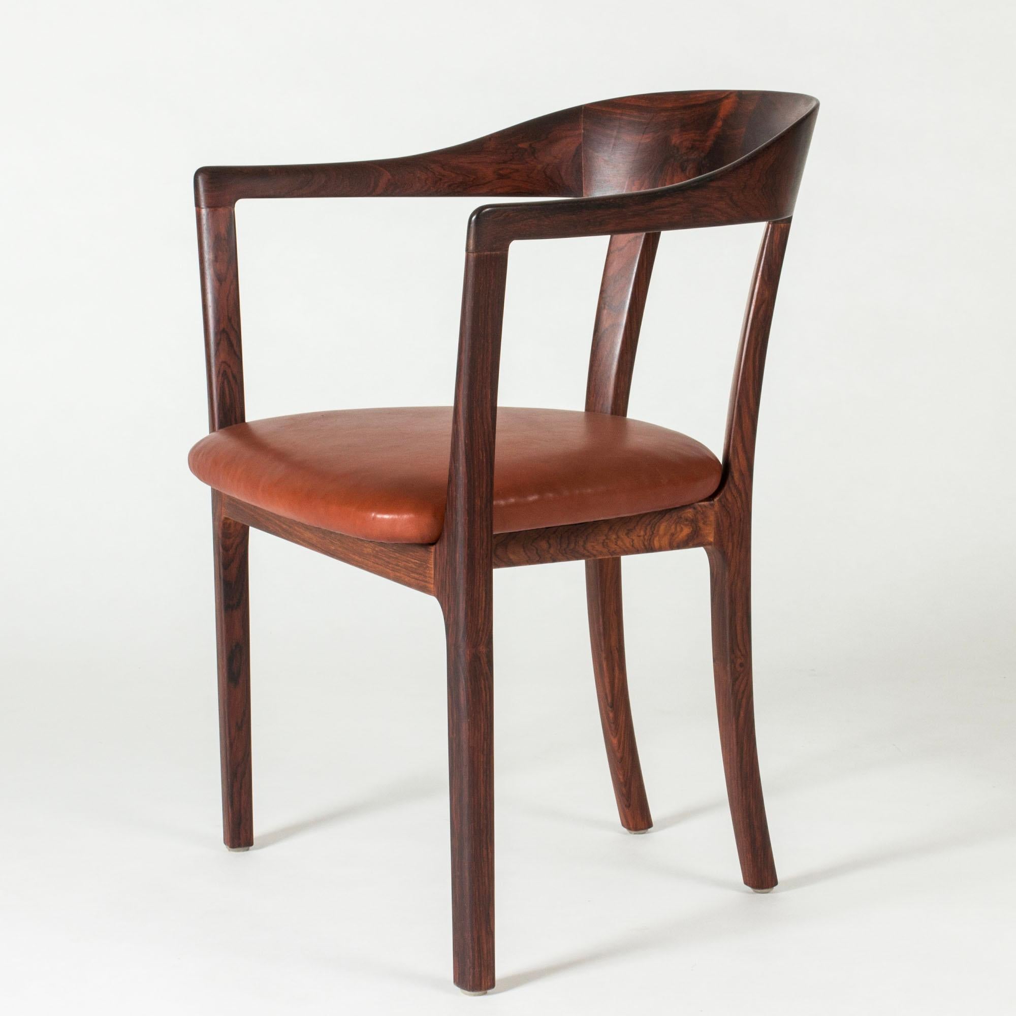 Beautiful rosewood armchair by Ole Wanscher, upholstered with a cognac leather seat. Smooth organic lines and striking, lively woodgrain.