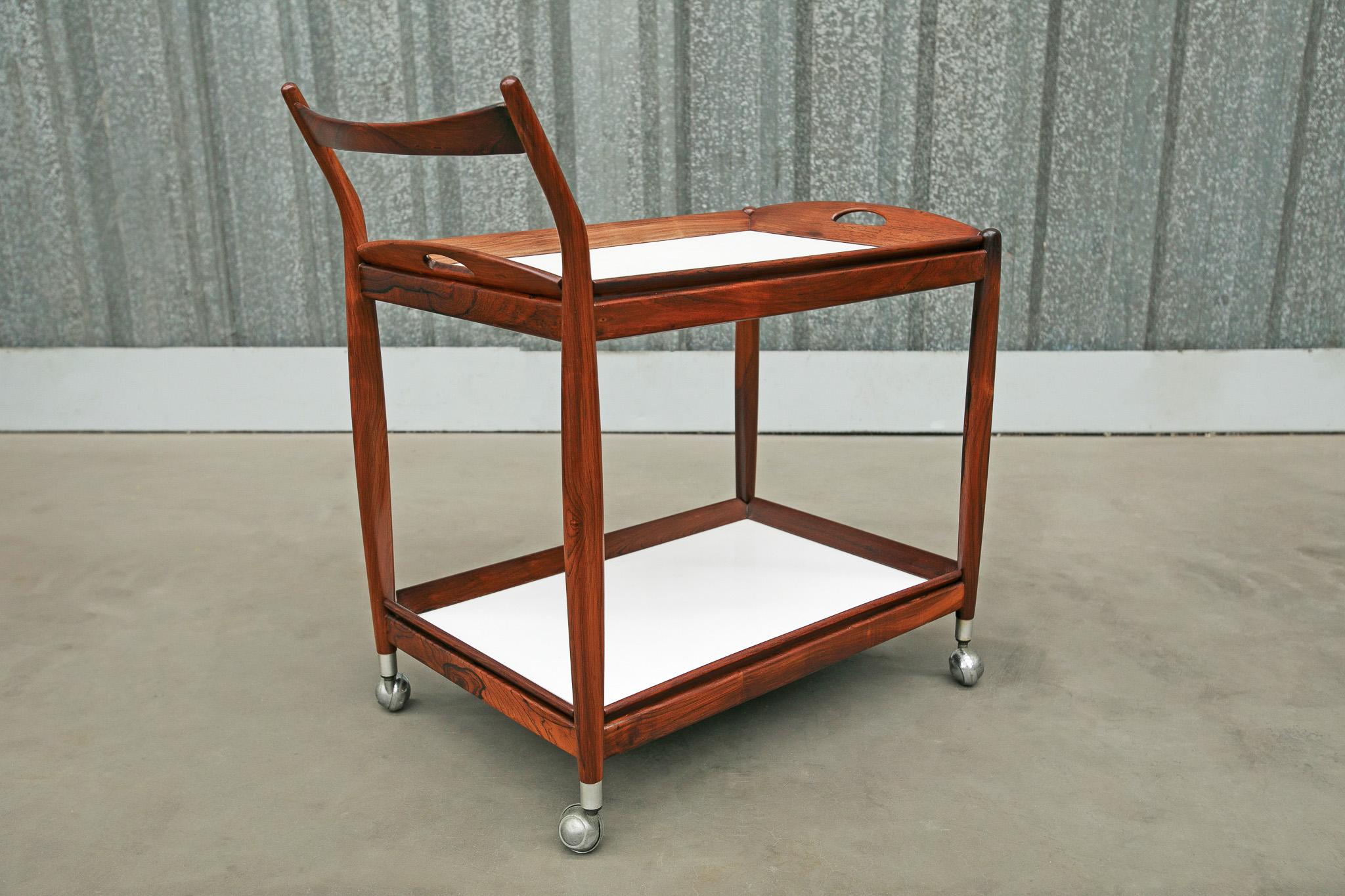 Available today, this Mid-Century Modern Bar cart in Hardwood and White Formica designed by Sergio Rodrigues in Brazil in the 60s is nothing less than spectacular! 

The bar cart is entirely made in Brazilian Rosewood (known as Jacaranda) with the
