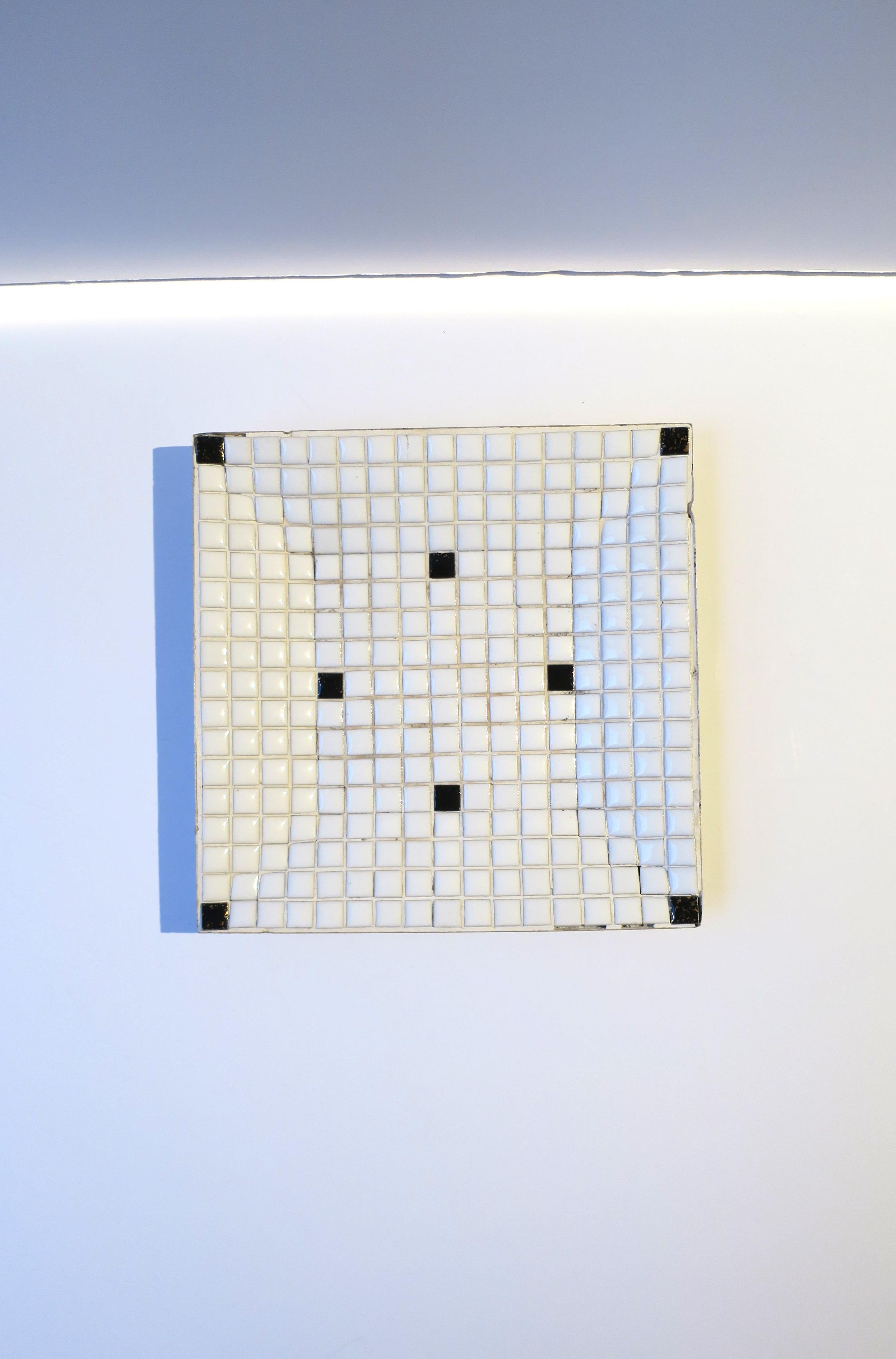 A black and white tile mosaic dish or catchall vide-poche, Midcentury Modern period, circa mid-20th century, 1960s, USA. Dish is predominantly white with a few black tiles, finished with a metal bottom. Dimensions: .75
