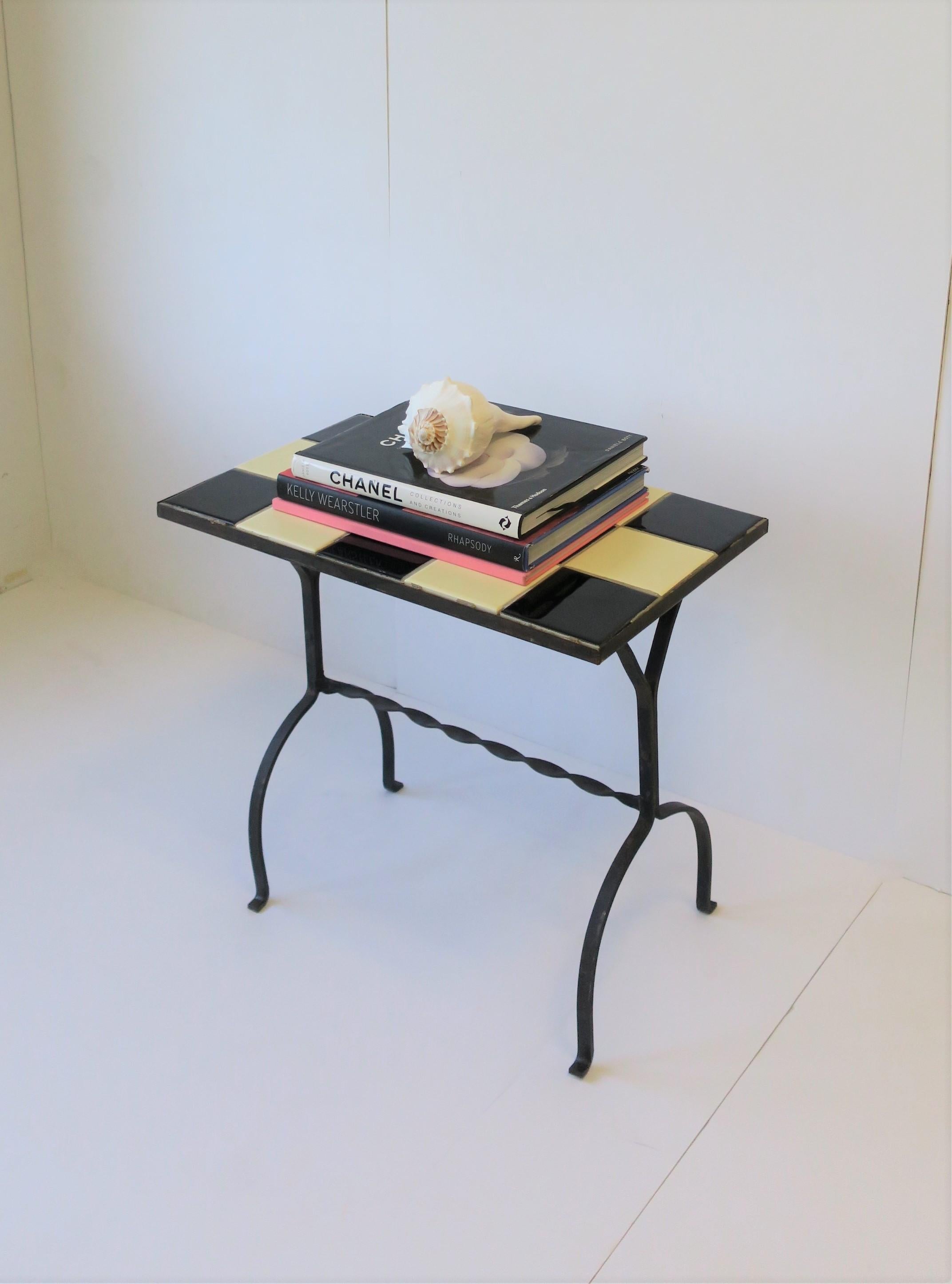 A Mid-Century Modern rectangular black and white ceramic mosaic tile end, side, or drinks table, circa mid-20th century. Table has a black metal frame with black and white ceramic tile top. Table offers a great look with its alternating black and
