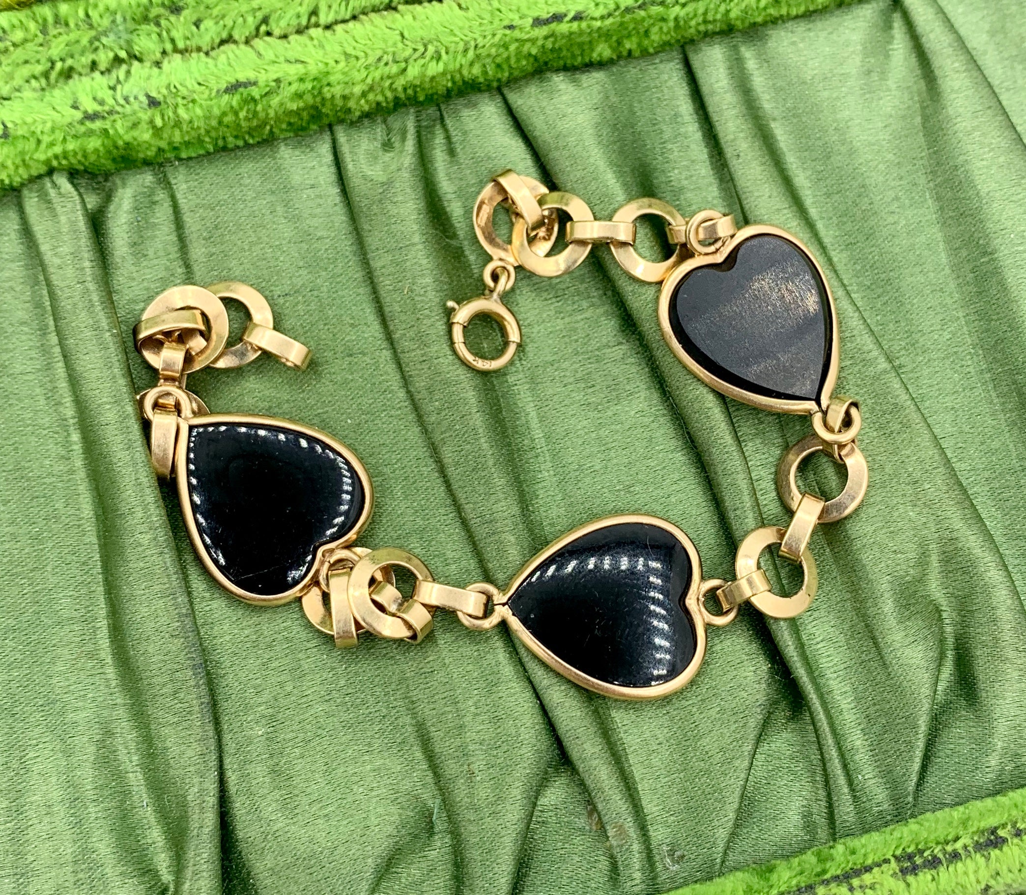 This is an exquisite Mid-Century Modern Eames Era period Bracelet with stunning Black Onyx Hearts set in 14 Karat Rose Gold.   The elegant clean lines of the onyx hearts and the circular gold links epitomize Mid-Century jewelry design.  The bracelet