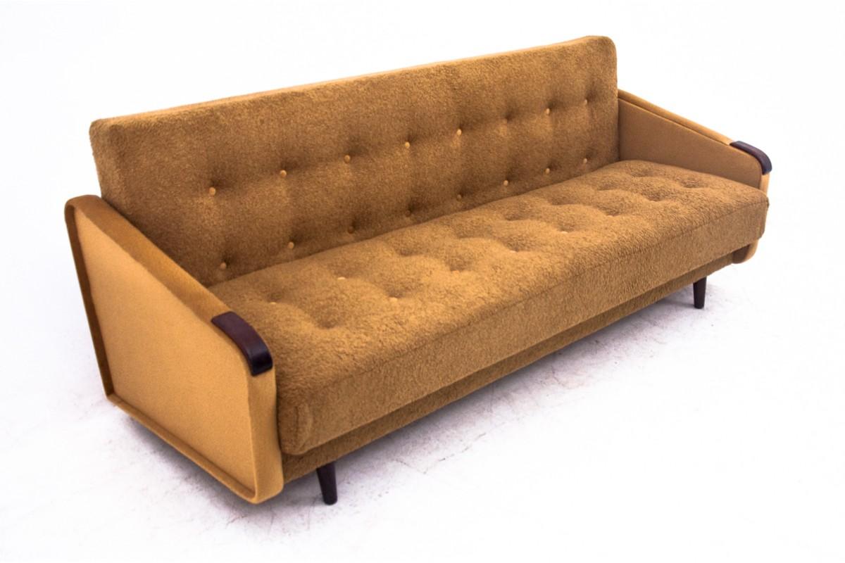 Das Sofa aus den 1960er Jahren wurde in Dänemark hergestellt.
Möbel in sehr gutem Zustand, nach professioneller Renovierung. 
Das Sofa wurde mit einem neuen gelben Bouclestoff bezogen.
Man kann das Sofa ausklappen und ein Schlafsofa daraus