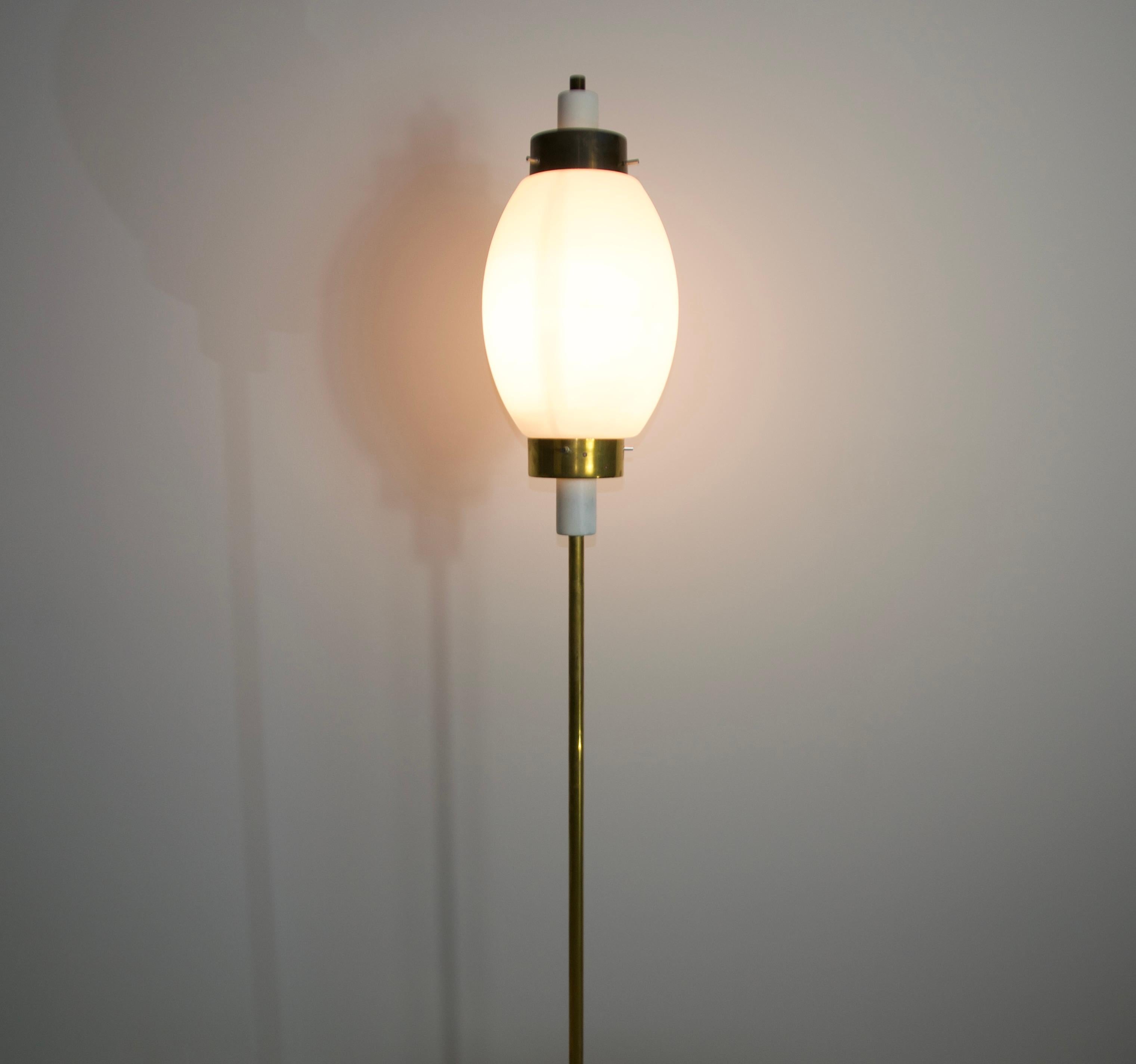 This exquisite mid-century modern floor lamp, crafted in Italy during the 1960s, captures the essence of timeless sophistication and exceptional design. Inspired by the iconic Stilnovo style, the lamp features a gracefully curved opaline glass shade