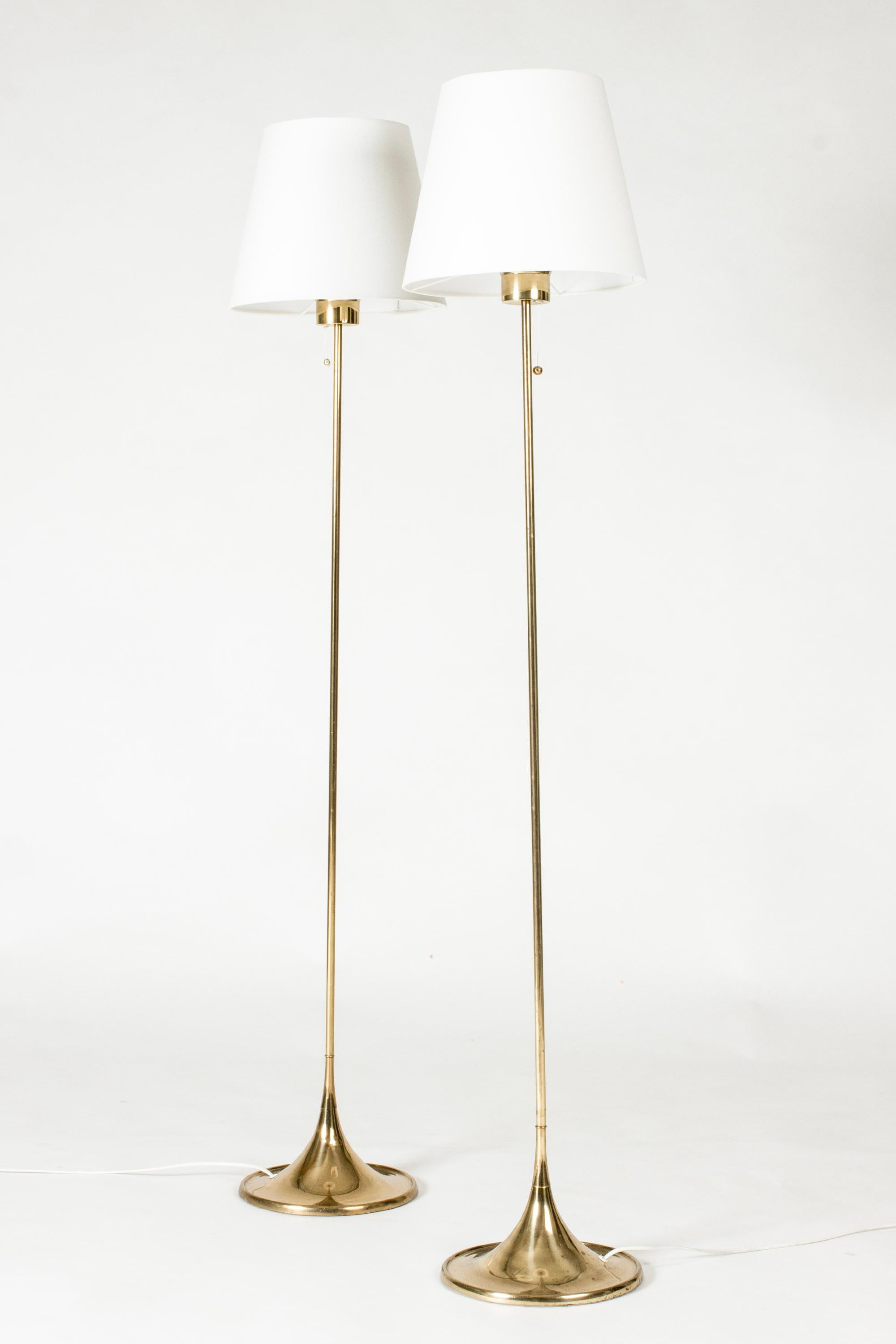 Pair of elegant brass floor lamps from Bergboms, in a sleek, elegant design. Nicely streamlined bases.