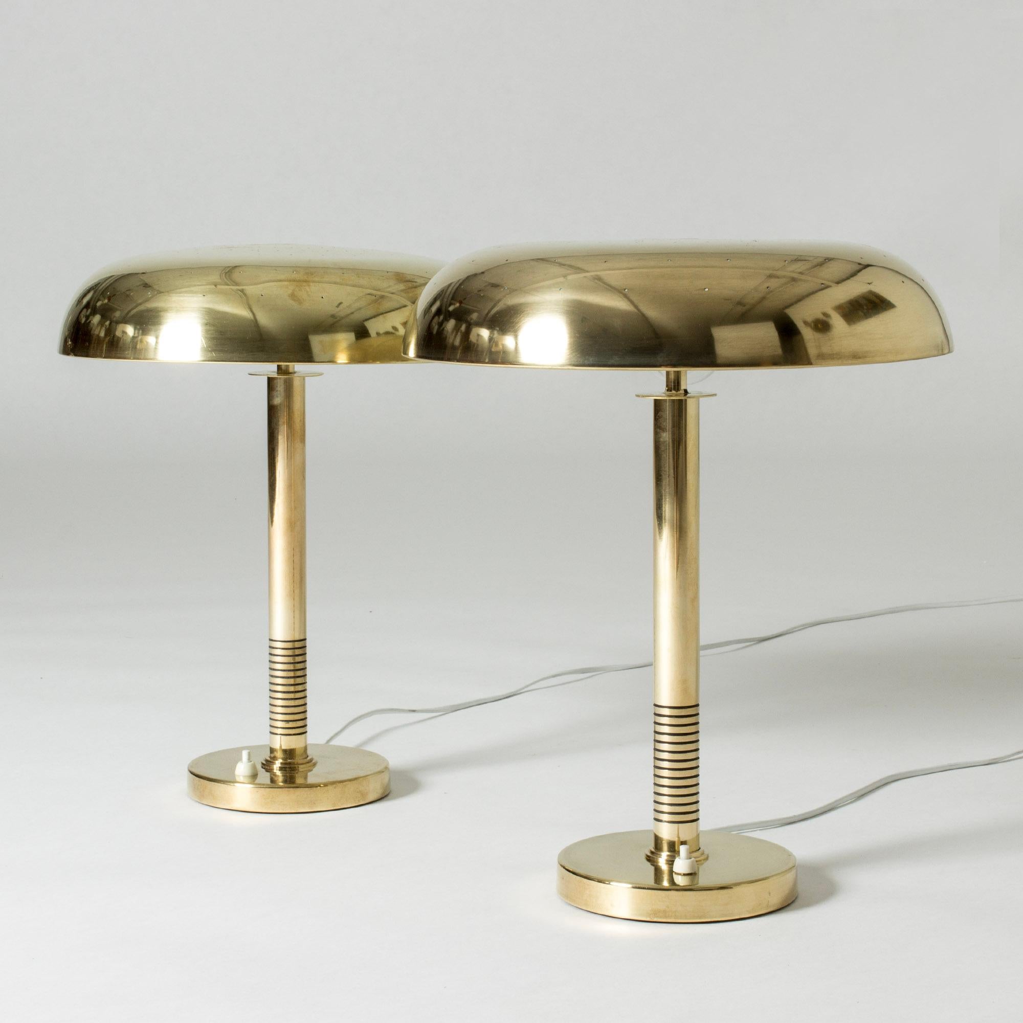Pair of sleek table lamps from Boréns, made from brass. Wide brass shades with rounded forms, bases with elegant stripes.
