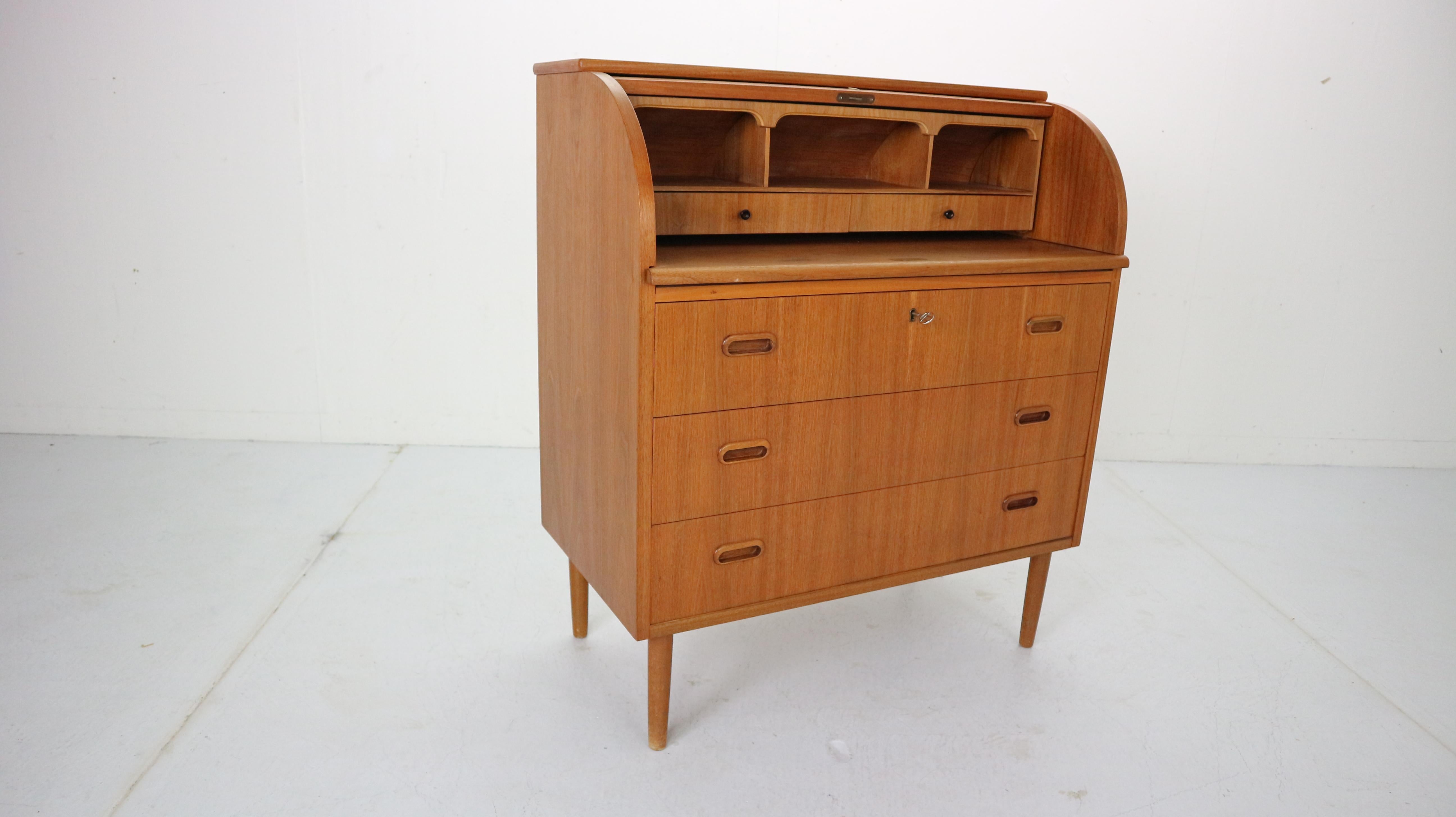 This iconic midcentury Swedish modern teak cylinder rolltop secretary- desk- cabinet is made in 1970's Sweeden by Egon Ostergaard designer and manufactured by Markaryds Mobelindustri manufacture. 
The Classic Scandinavian Modern design has clean