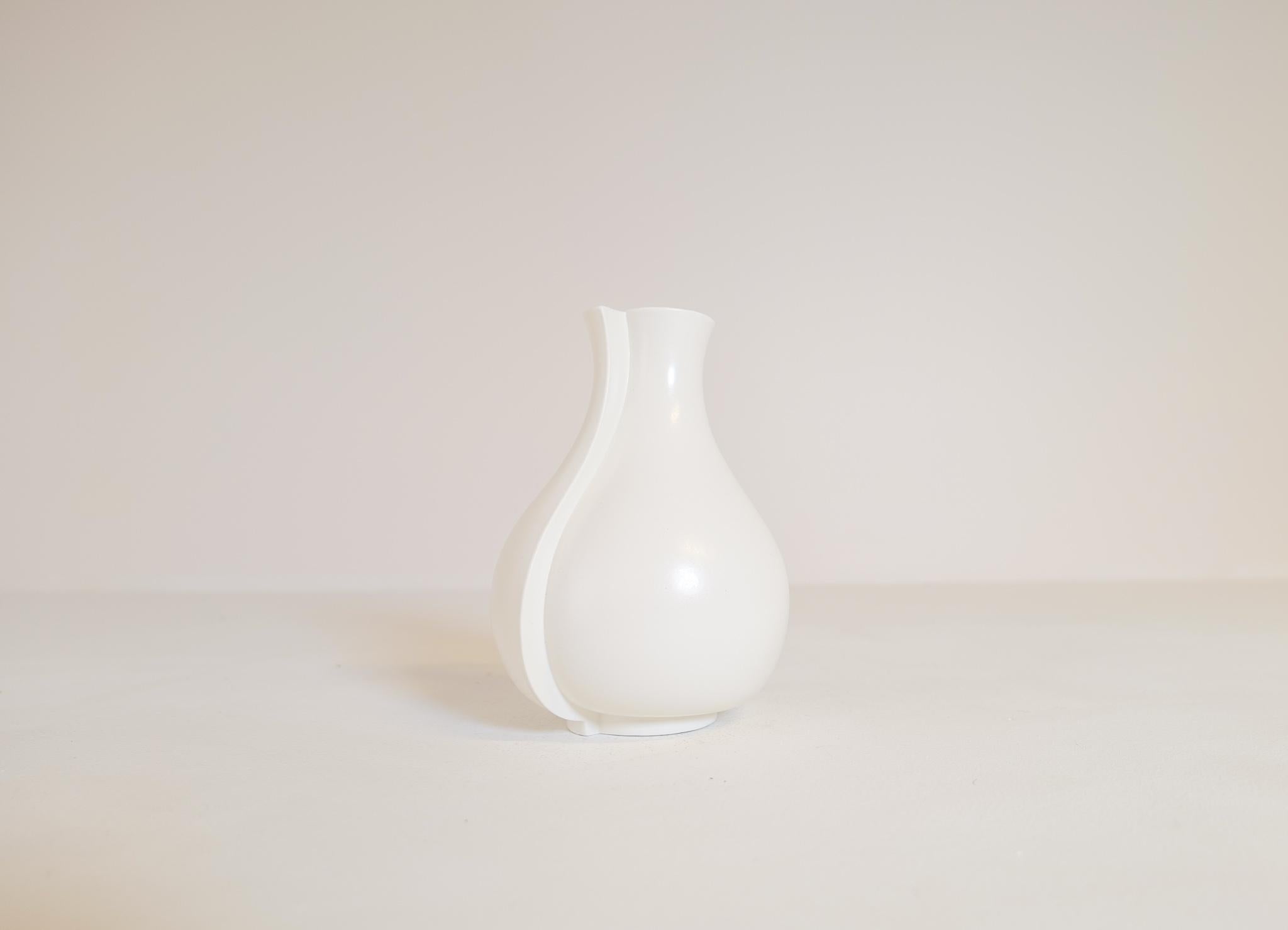 Diese abstrakte, mattweiße Steinzeugvase mit dem Namen Surrea (surreal) wurde von Wilhelm Kåge in den 1950er Jahren entworfen und in Gustavsberg, Schweden, hergestellt. Diese Vase eignet sich perfekt für ein modernes Haus. 

Wir haben mehr von