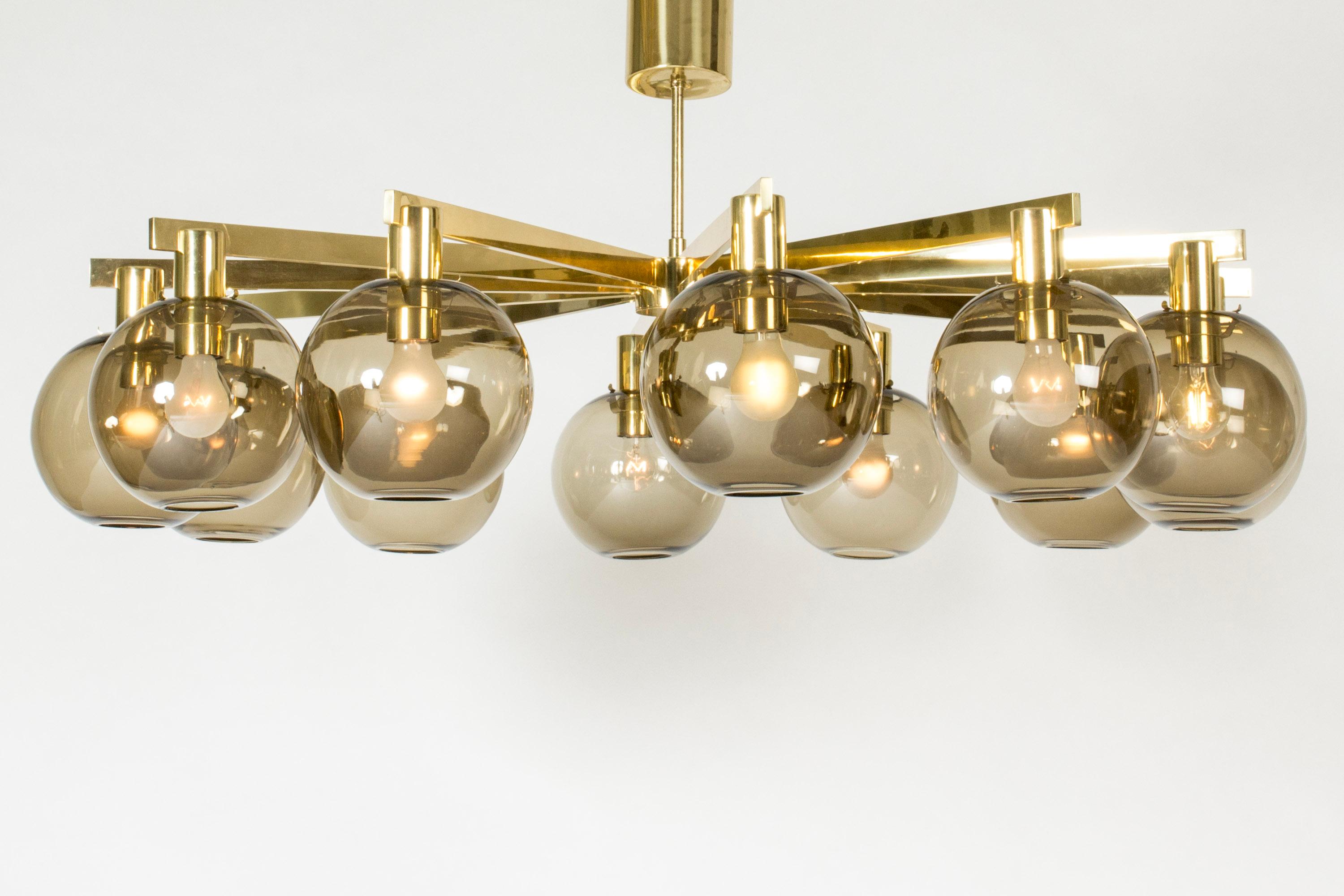 Amazing, oversized chandelier by Hans-Agne Jakobsson, made from brass with twelve smoke colored spherical glass shades. Clean design, suspending pole length can be customized.