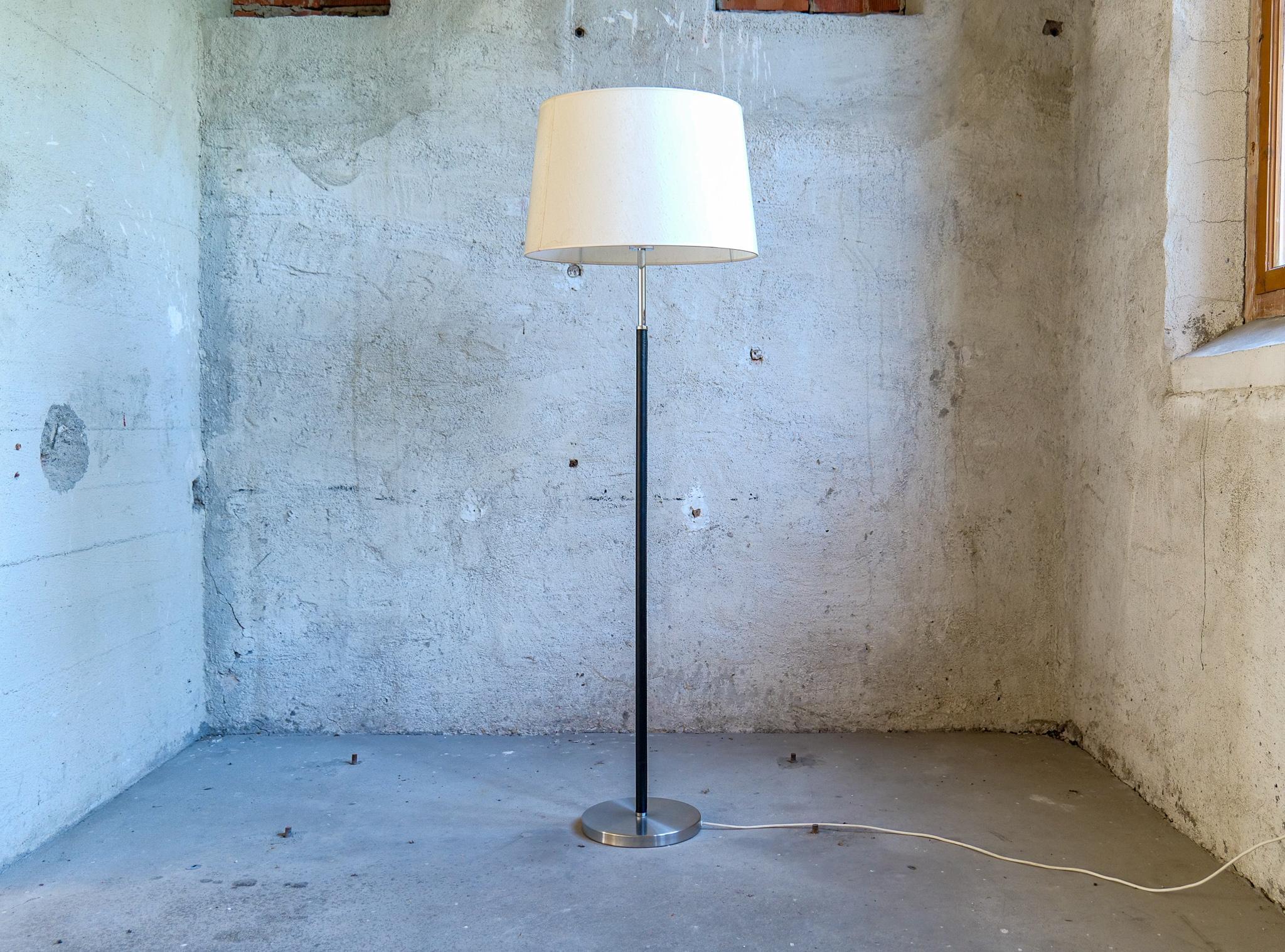 This rare floor lamp is designed by Anders Pehrson who took over the business of Atelje´ Lyktan in 1964. The lamp has a chrome base with a leather rod and chrome on the other parts. Original shades with acrylic plastic on the inside. 

Nice working