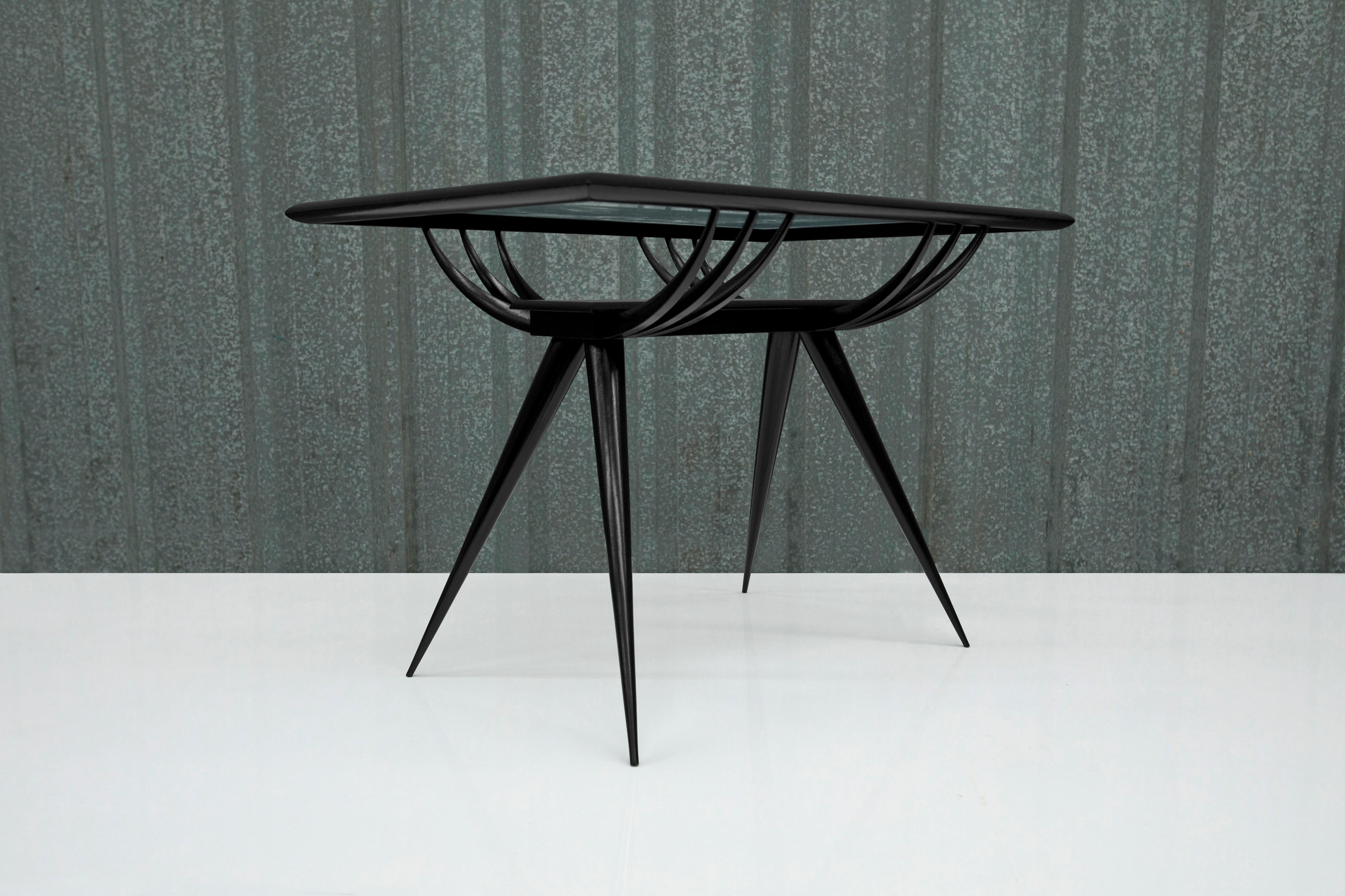 Available today, this Brazilian Modern coffee table in Hardwood and Glass by Giuseppe Scapinelli, 1950s, Brazil is absolutely gorgeous!

The coffee table is made in hardwood painted in black, and features four toothpick legs, a middle shelf and