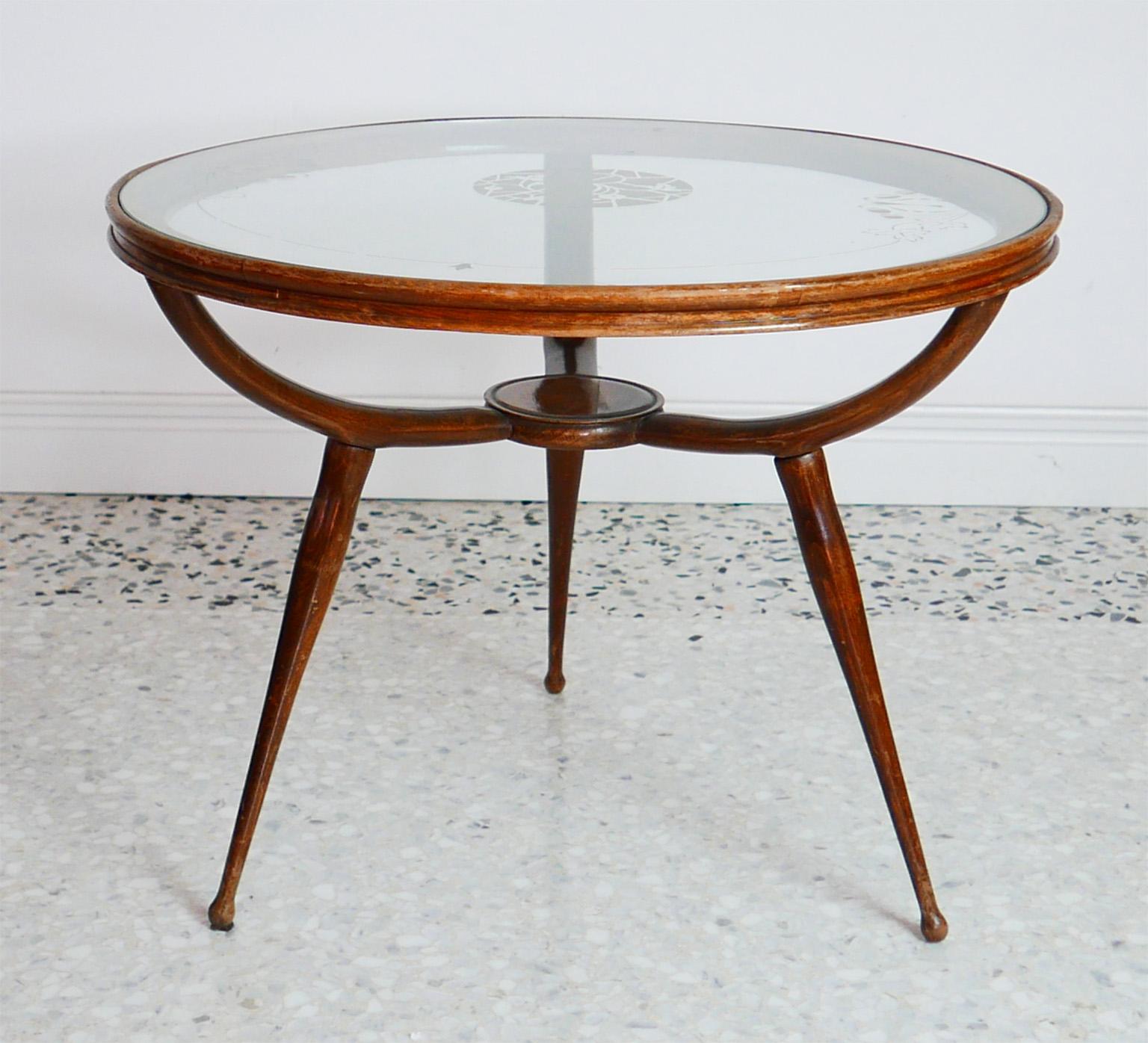 Round coffee table, with tripode leg, mahogany structure and glass top inserted in the wooden circle.
The deisgn Recalls that of Carlo de Carli semplified.
The etched top glass can be easily replaced.