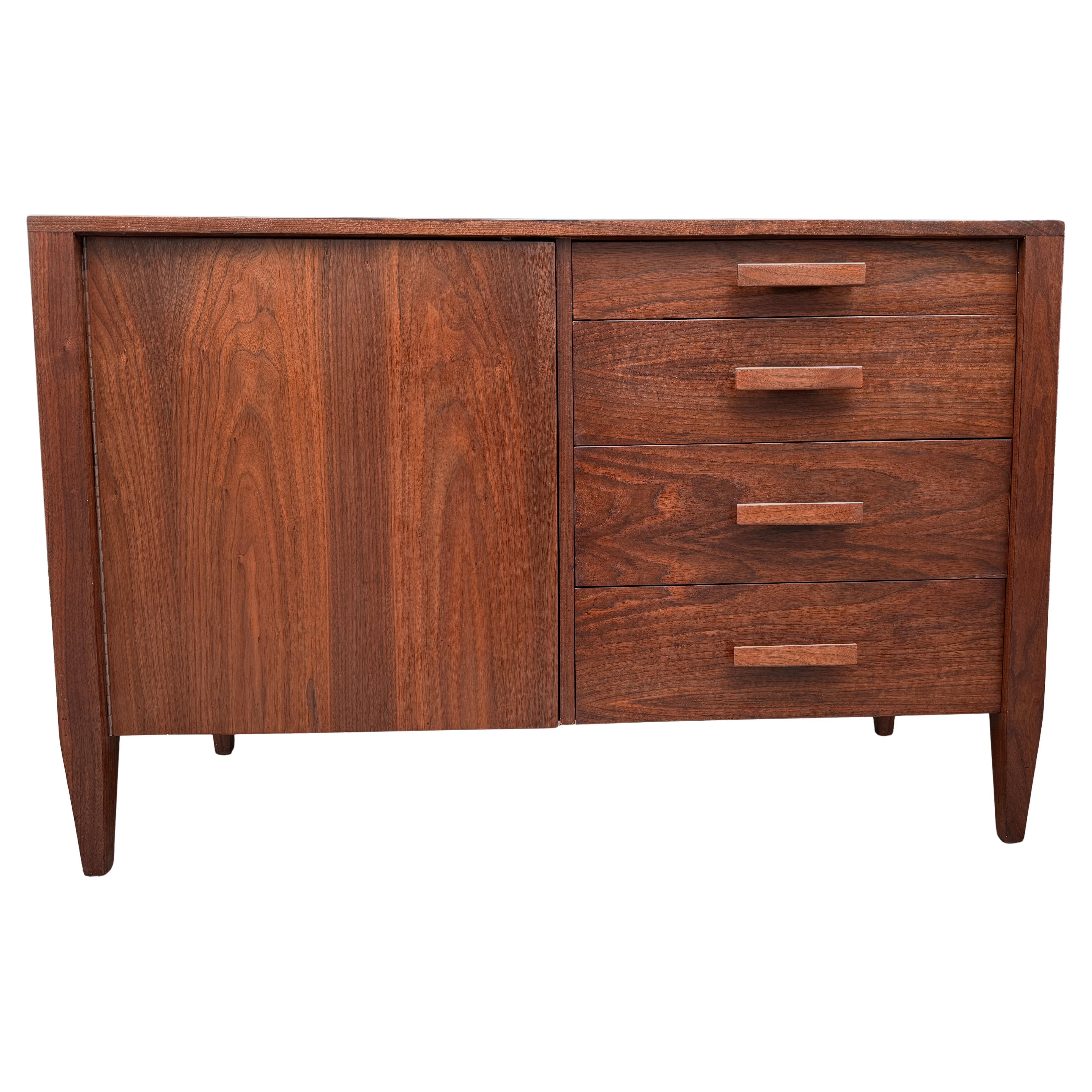A superb handcrafted American Modern cabinet in rich black walnut, dating to the 1960s. This solid, well-built piece features four exposed drawers and one open cabinet with an internal drawer and an adjustable shelf—offering both style and versatile