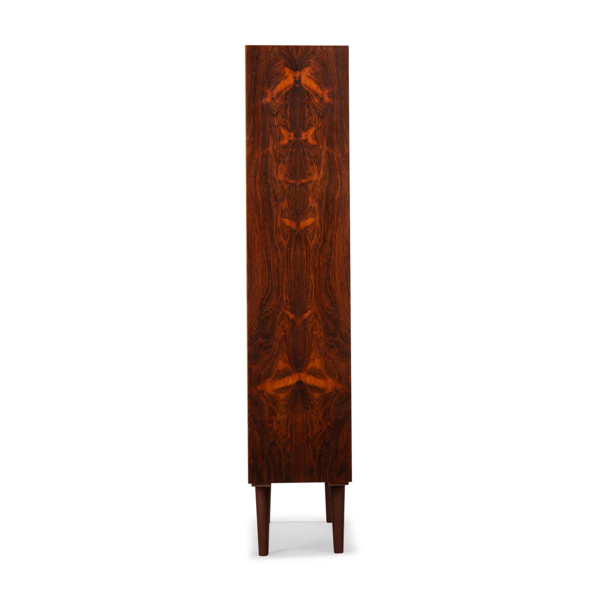 Bookcase
Danish bookcase in beautiful rosewood veneer. Designed by Carlo Jensen and made by Hundevad & Co. 
Marked by 2 stamps! However, a Hundevad bookcase can always be recognized by the planks that are beveled.

The drawing of the rosewood is