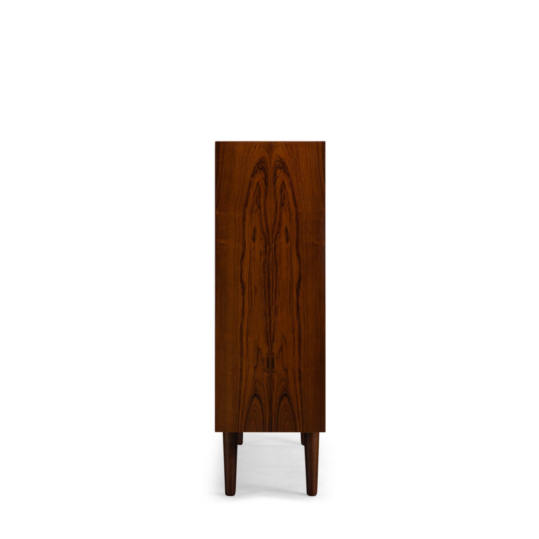 Danish low bookcase in beautiful rosewood veneer. Designed by Carlo Jensen and made by Hundevad & Co. The sticker on the back has fallen off over the years. But a Hundevad bookcase can always be recognized by the planks that are beveled.

This