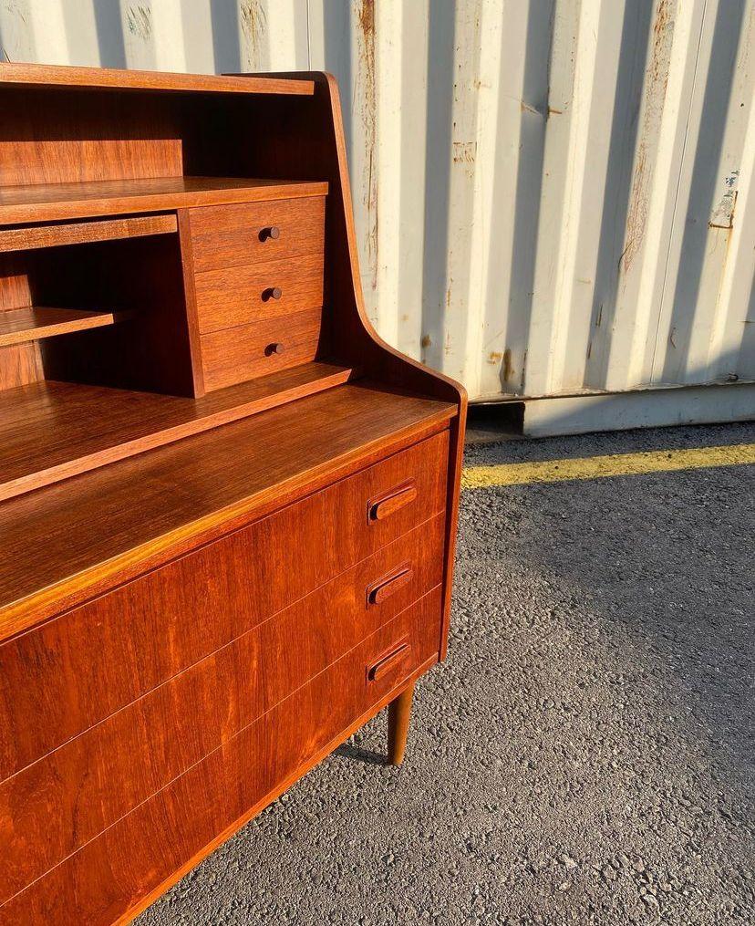 Midcentury modern danish teakwood secretary/vanity, 1960s Denmark.

Features a vibrant wood grain, a set of six small drawers, mail slots and slide out writing desk with a hidden mirror on its top while the lower end offers three large dove tail