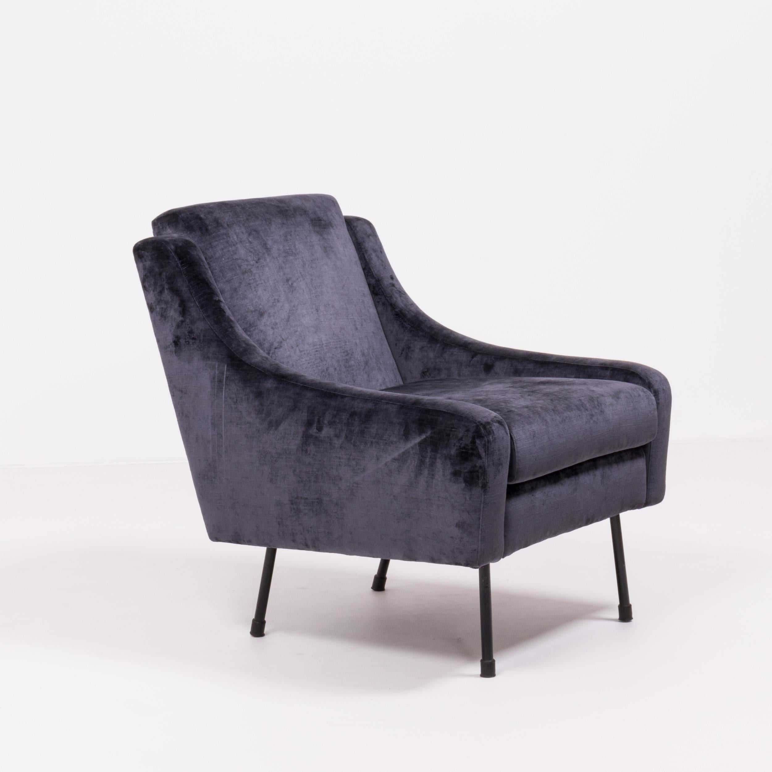 The perfect combination of sleek lines and soft curves, this midcentury armchair is a fantastic example of timeless Mid-Century Modern design.

Fully upholstered in Prussian blue velvet, the chair features a high back and curved arms. The angled