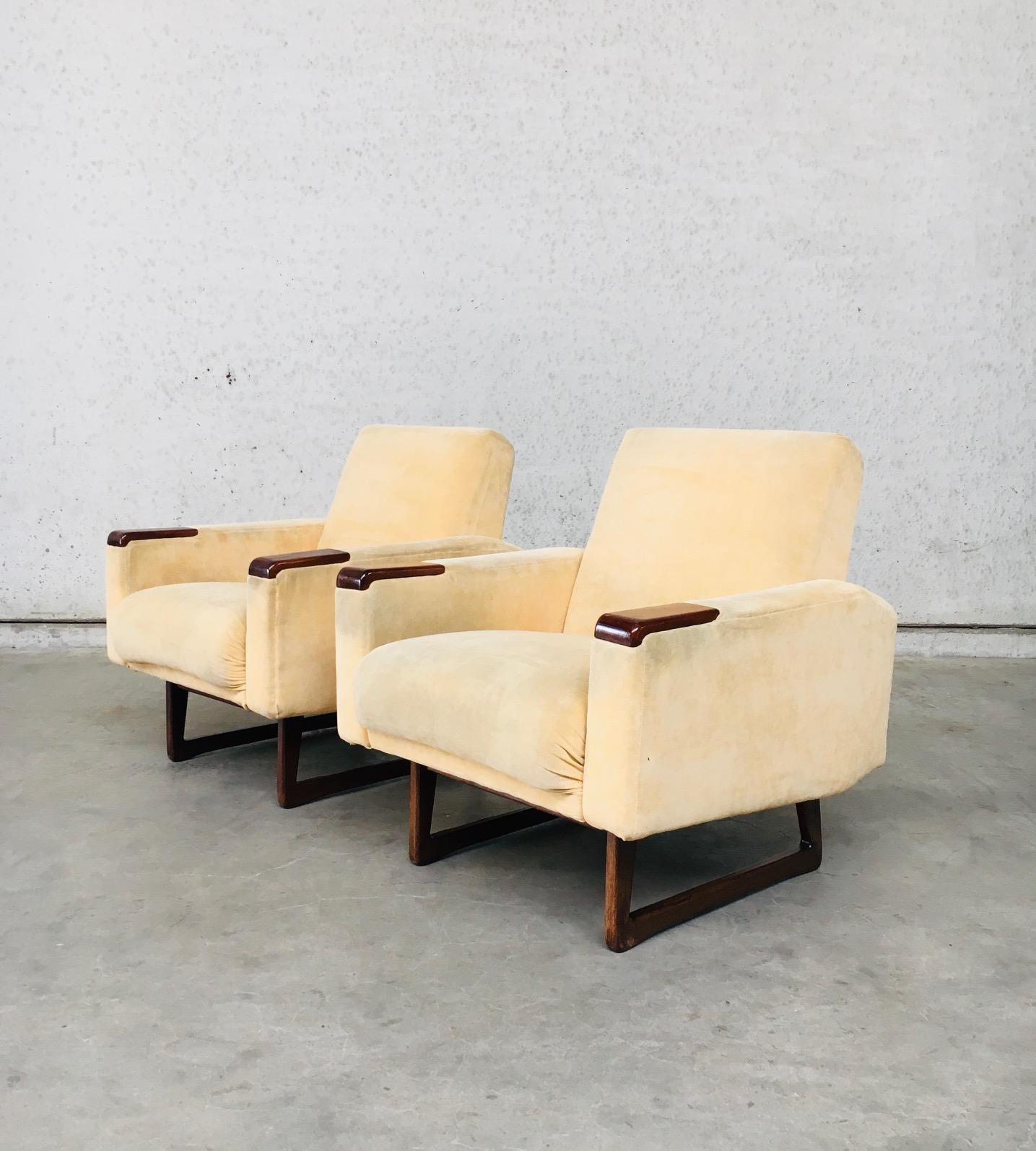 Vintage Midcentury Scandinavian Design Armchair set of 2, made in Denmark 1950's / 60's. Pale yellow velvet frabric with teak (look) wooden set in on the arm rests, and teak (look) wooden U-formed feet base. The fauteuil set is all original and in