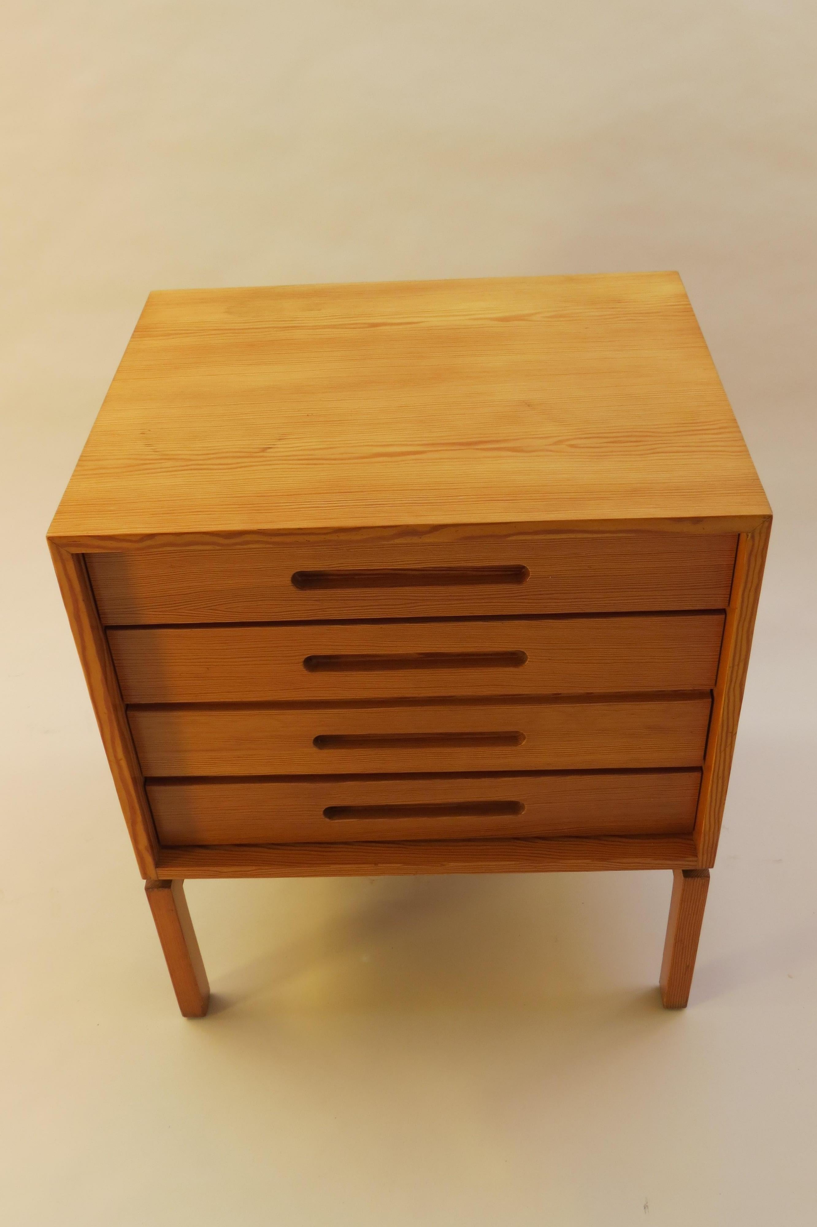 Wonderful chest of drawers dating from the 1970s. Made from solid and veneered Oregon pine.  The piece has four drawers that open with recessed handles. Lovely figurative grain to the wood to the sides and top.
The chest has pad feet to the