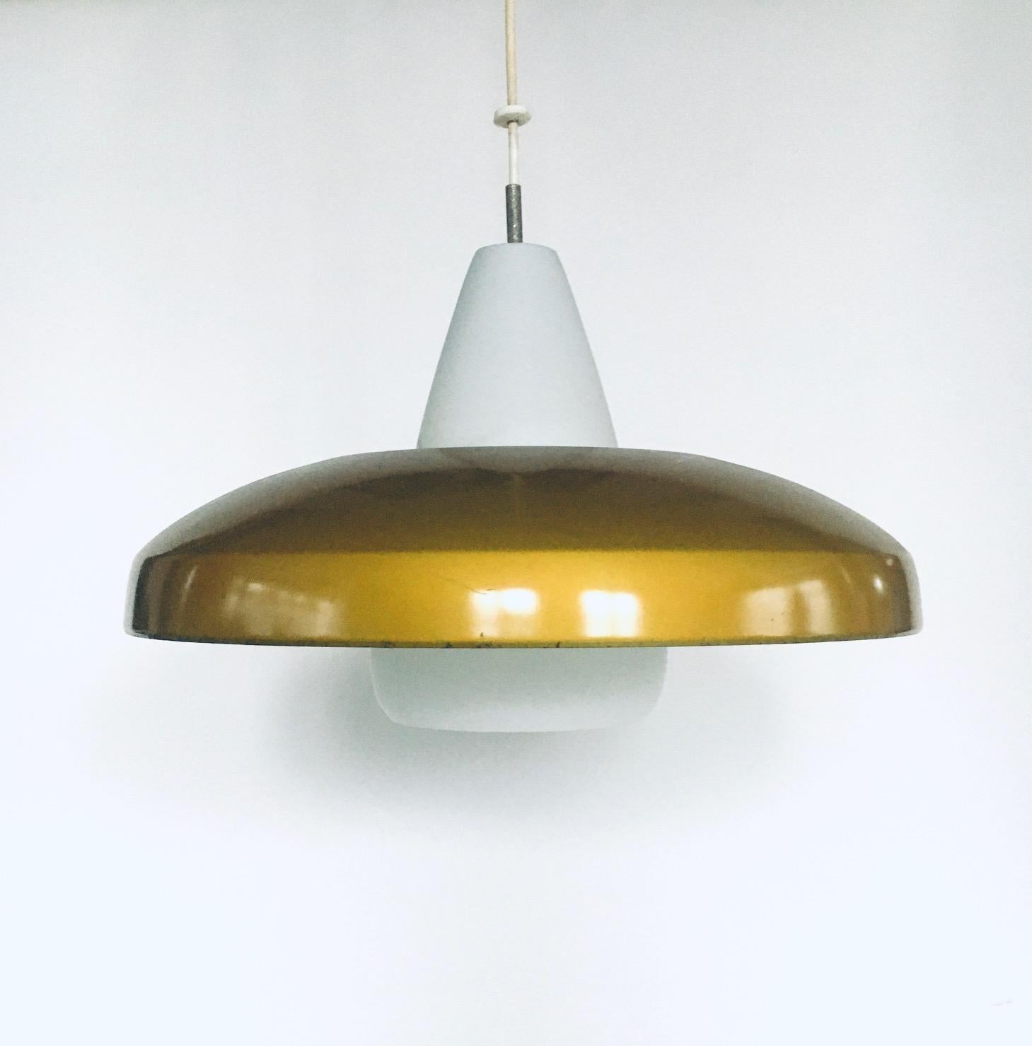 Vintage Mid-Century Modern Dutch design pendant lamp by Philips, made in the Netherlands, 1950s. Gold metal shade with white inner on opaline milk glass pendant. All original hanging system. In very good condition, some minor chipping on the top