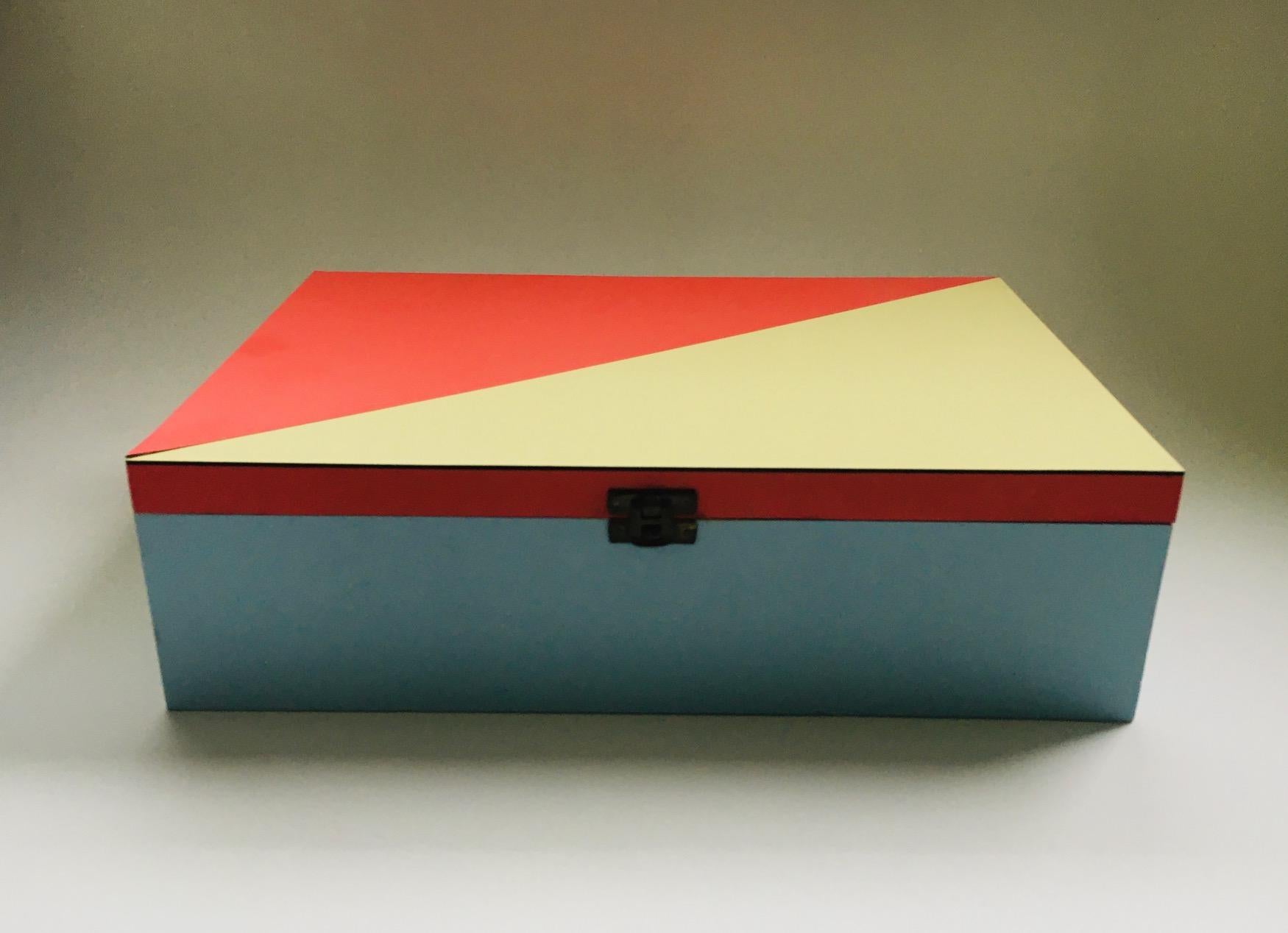 Boîte aux lettres Vintage Midcentury Modern Dutch Design dans le style du Modernisme DE STIJL. Fabriqué en Hollande dans les années 1950. Boîte en bois, finition en stratifié bleu pâle, rouge doux et jaune pâle avec motif géométrique. Intérieur en