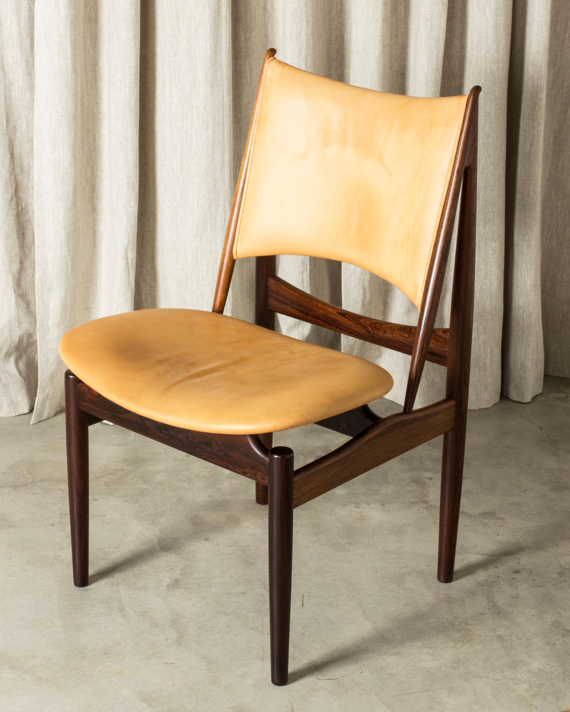 Beautiful “Egyptian Chair” by Finn Juhl, made in rosewood with natural leather. Unique, elegant design with distinct lines and subtle details. Juhl was inspired to create the design during a visit to the Louvre Museum and its collection of ancient