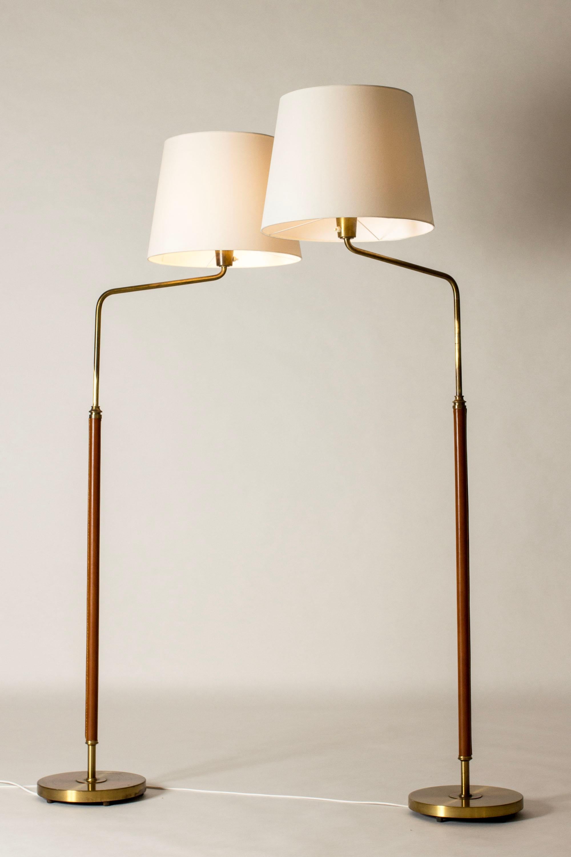 Ein Paar elegante Stehlampen von Bertil Brisborg, aus Messing in einer überragenden Größe. Stiele in cognacfarbenem Leder gekleidet.

