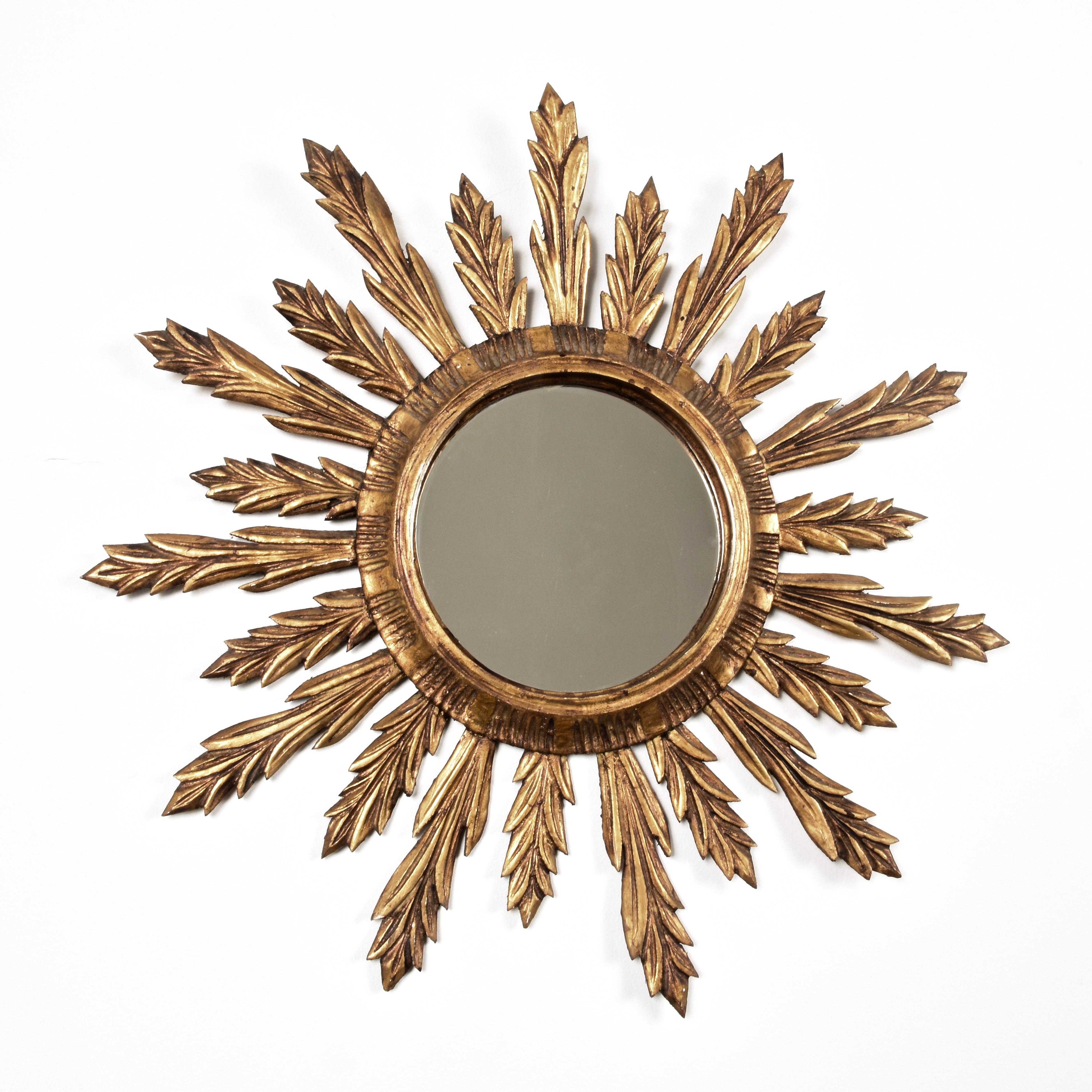 Wunderschöner Mid-Century Modern vergoldetes Holz sunburst Wandspiegel. Dieser erstaunliche Spiegel wurde in den 1950er Jahren in Frankreich hergestellt.

Die großen und kleinen Sonnenstrahlen sind einfach herrlich, denn sie wirken wie