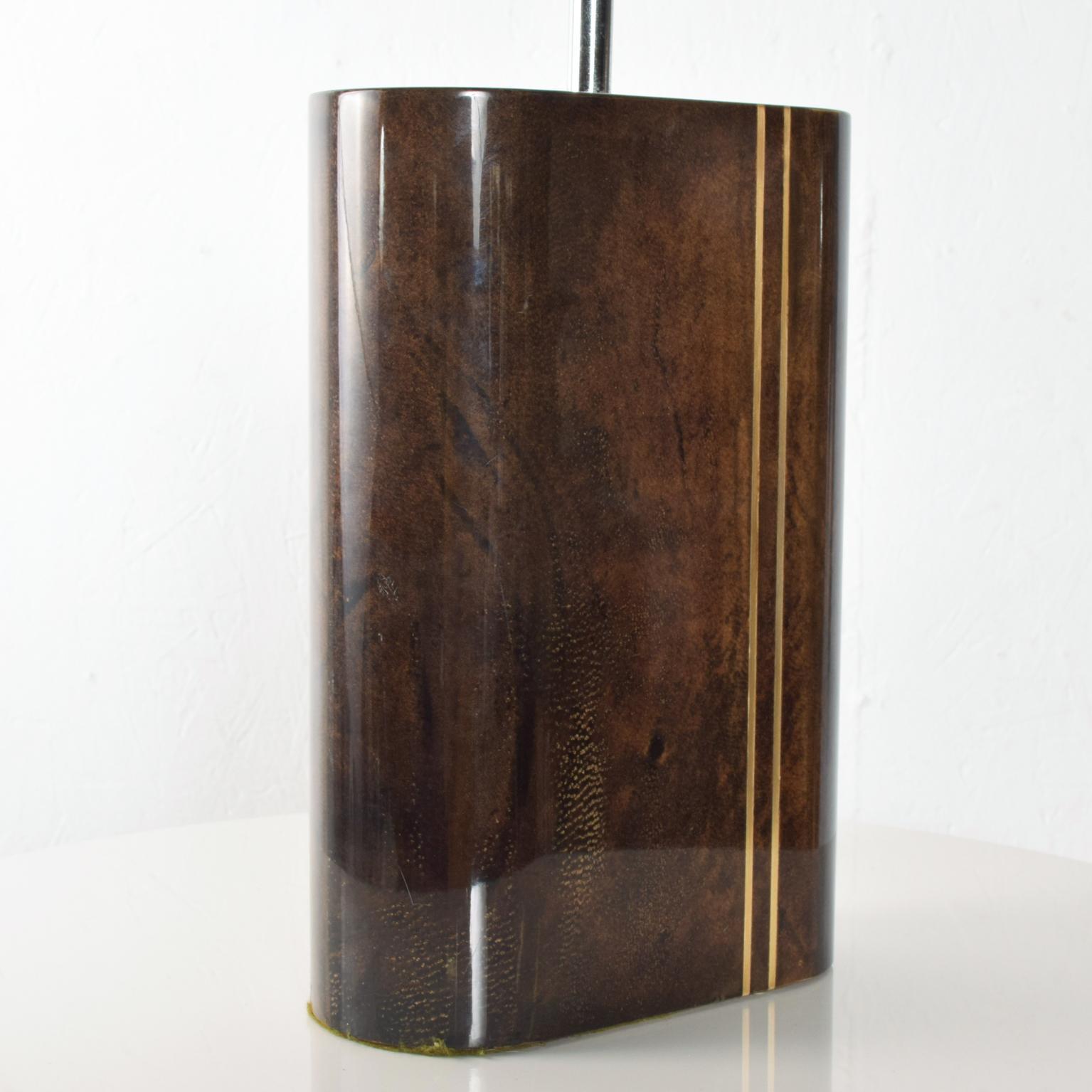 For your consideration a beautiful in near mint condition table lamp with an oval shape. Wood covered in goatskin brown tone with two metal inserts and high gloss polyester finish. Chrome-plated hardware. The lamp has been tested and currently