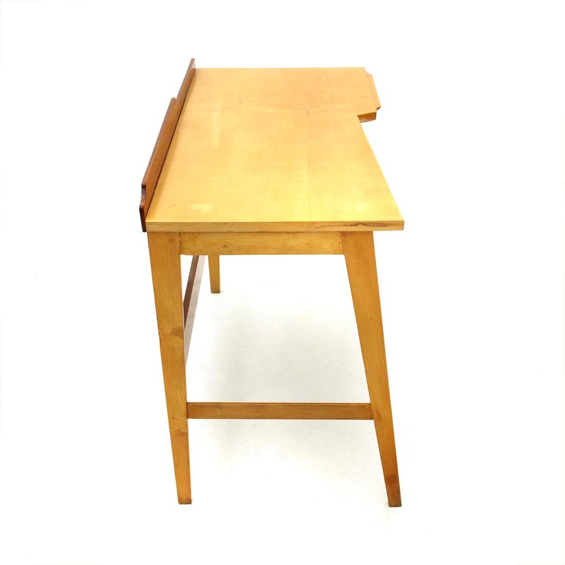 Italian made desk produced in the 1950s.
Solid wood structure.
Irregular shaped top in veneered wood with front edge.
Drawer with black painted metal handle.
Slightly inclined front legs that taper towards the end.
Good general condition, some