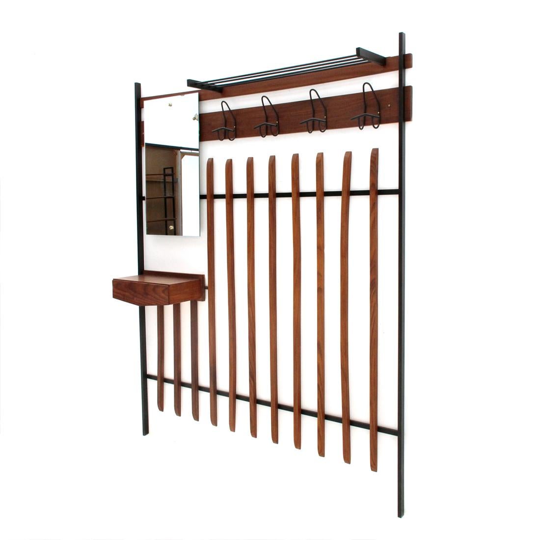 Italian-made clothes hanger produced in the 1960s.
Structure in black painted metal.
Horizontal panels and shelf with drawer in veneered wood.
Vertical strips in solid wood.
Mirror with brass studs.
Hooks in black painted metal.
Good general