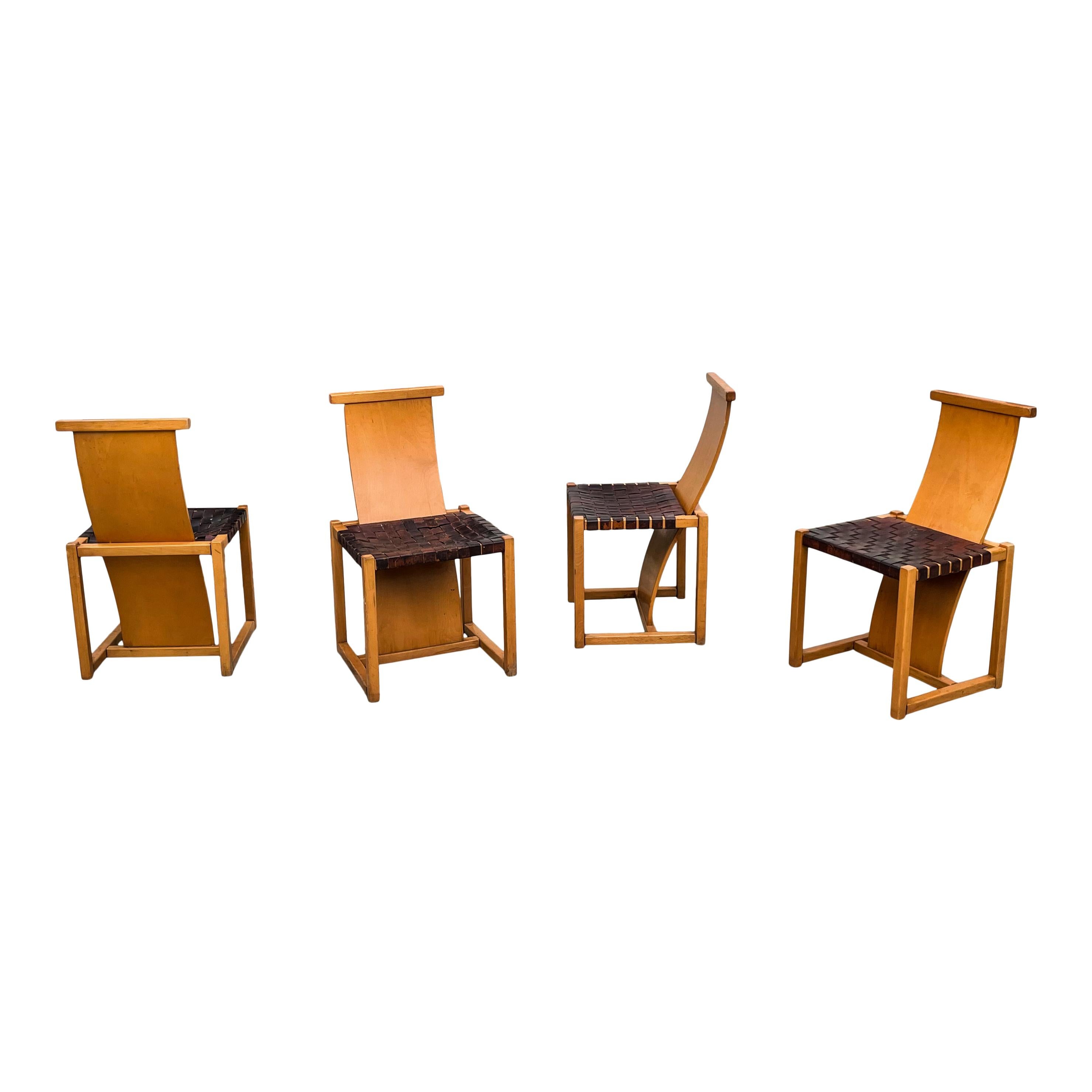 Set of four Italian dining chairs, made in the 70s.
They feature a beech wood structure and a brown woven leather seat.
The s-shaped backrest, linked with the squared legs, is the main feature of the chairs.
The shape and the woven leather remind