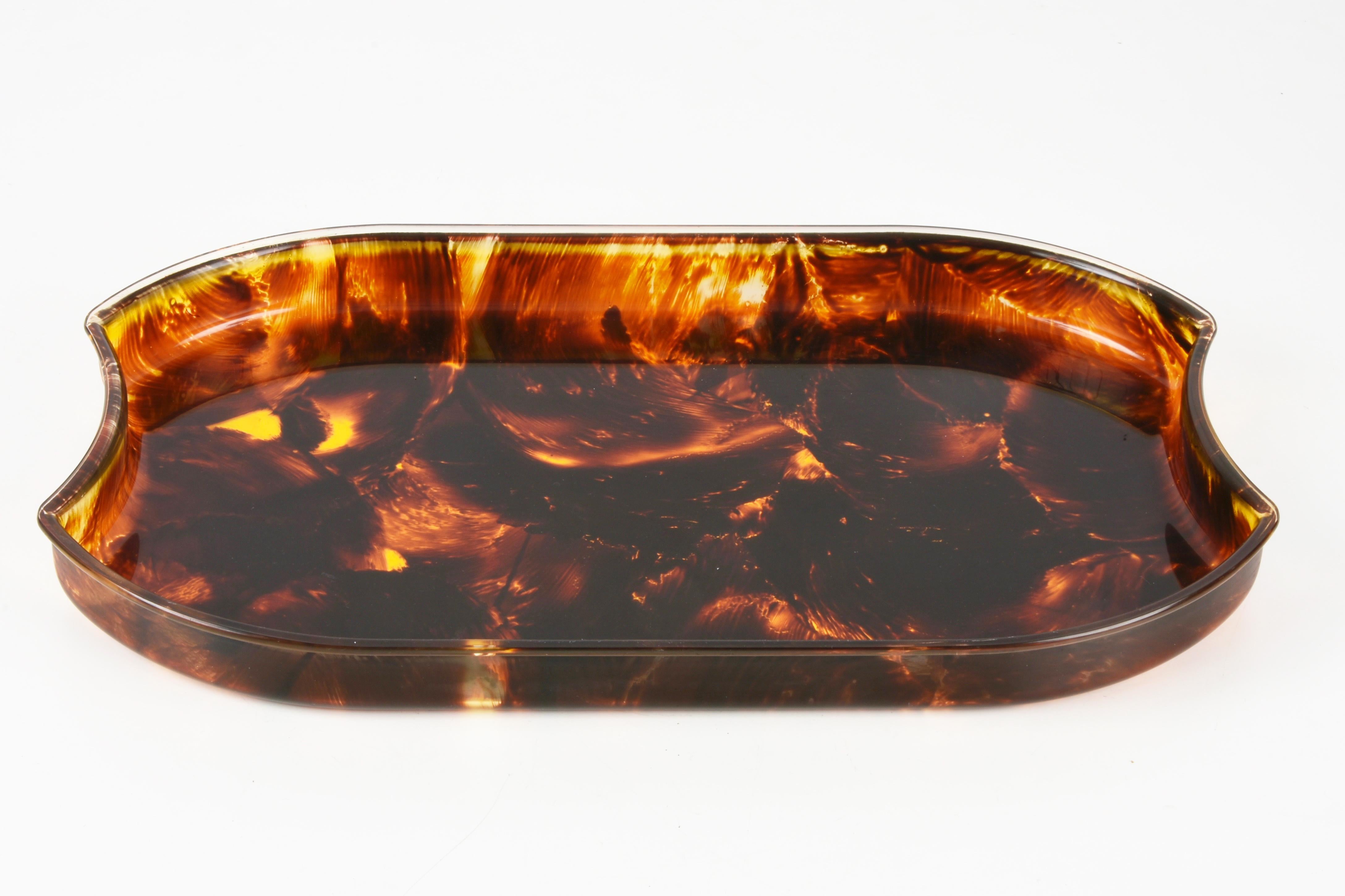 Wonderful Mid-Century lucite tray with a fantastic tortoiseshell effect. This amazing piece was designed in Italy during the 1970s.

This serving tray is fantastic thanks to the elegant shape and the lovely tortoiseshell effect lucite.

It's an