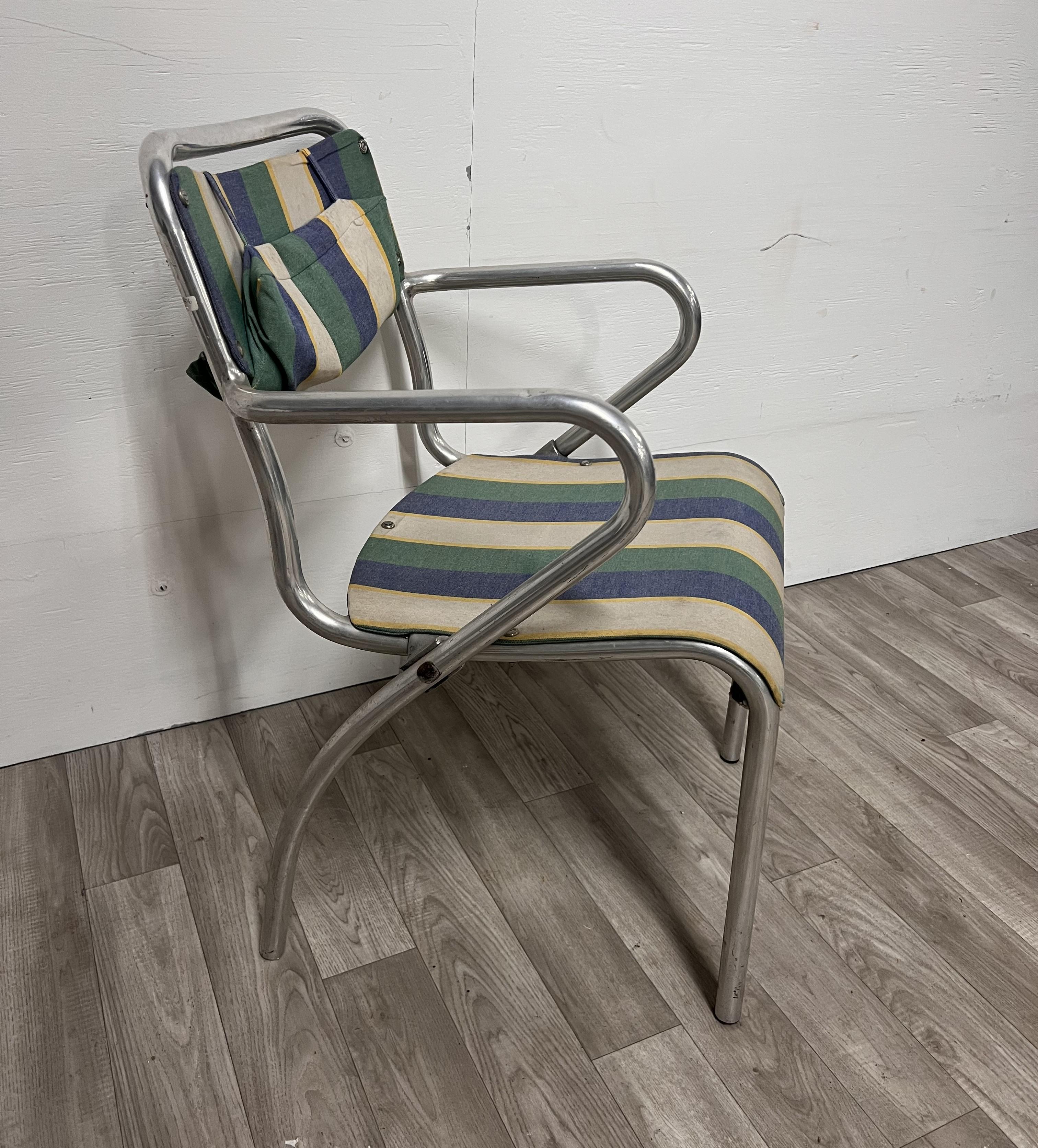 Producción italiana 1950 ca Silla tubular metálica con reposabrazos de tela a rayas 
Signos evidentes de envejecimiento