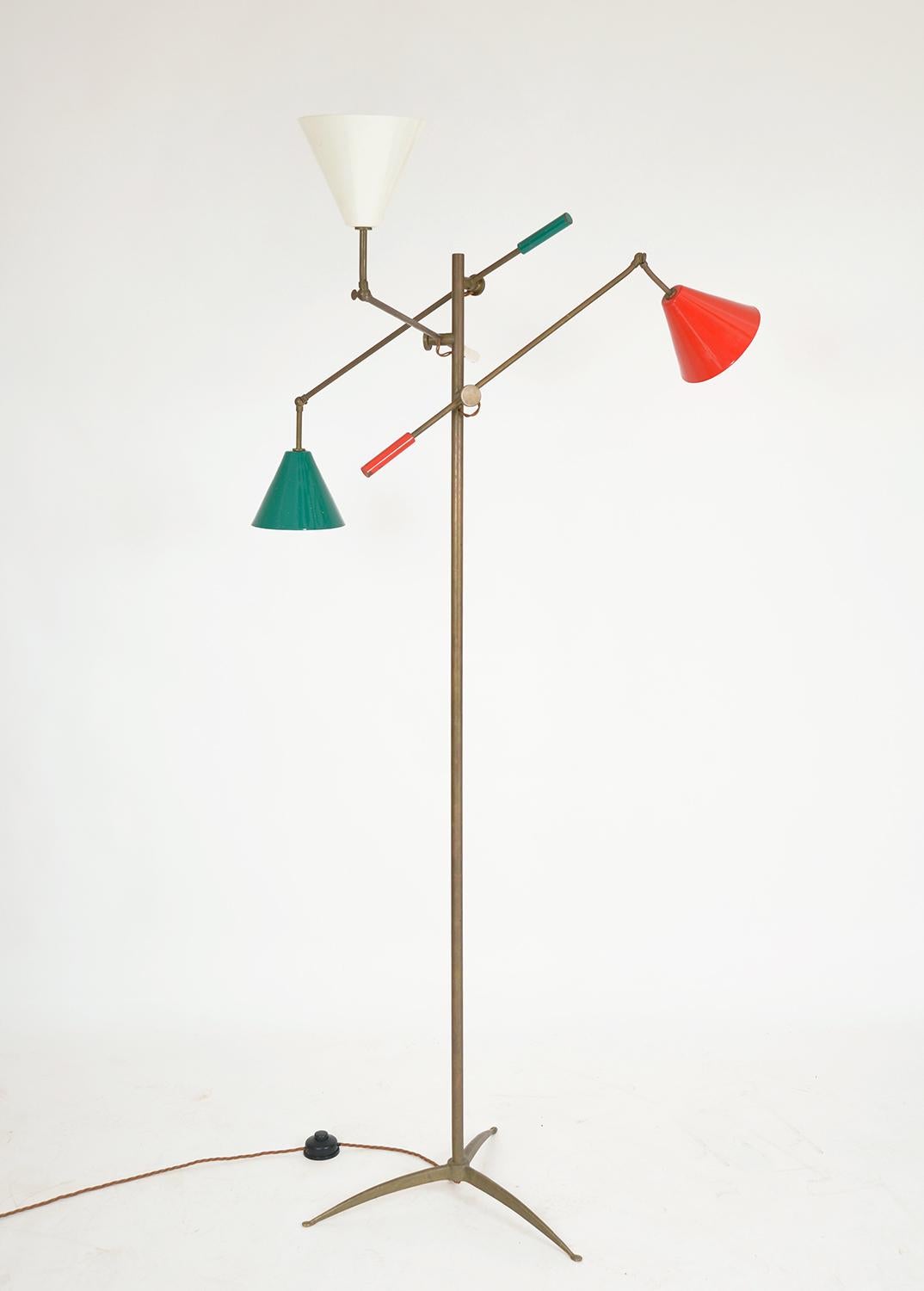 Incredibly stylish and timeless Mid-Century Modern three-arm articulated brass standard lamp with three adjustable brass arms with red, cream and green conical enamel shades and matching end rods. In good condition with great overall patina and