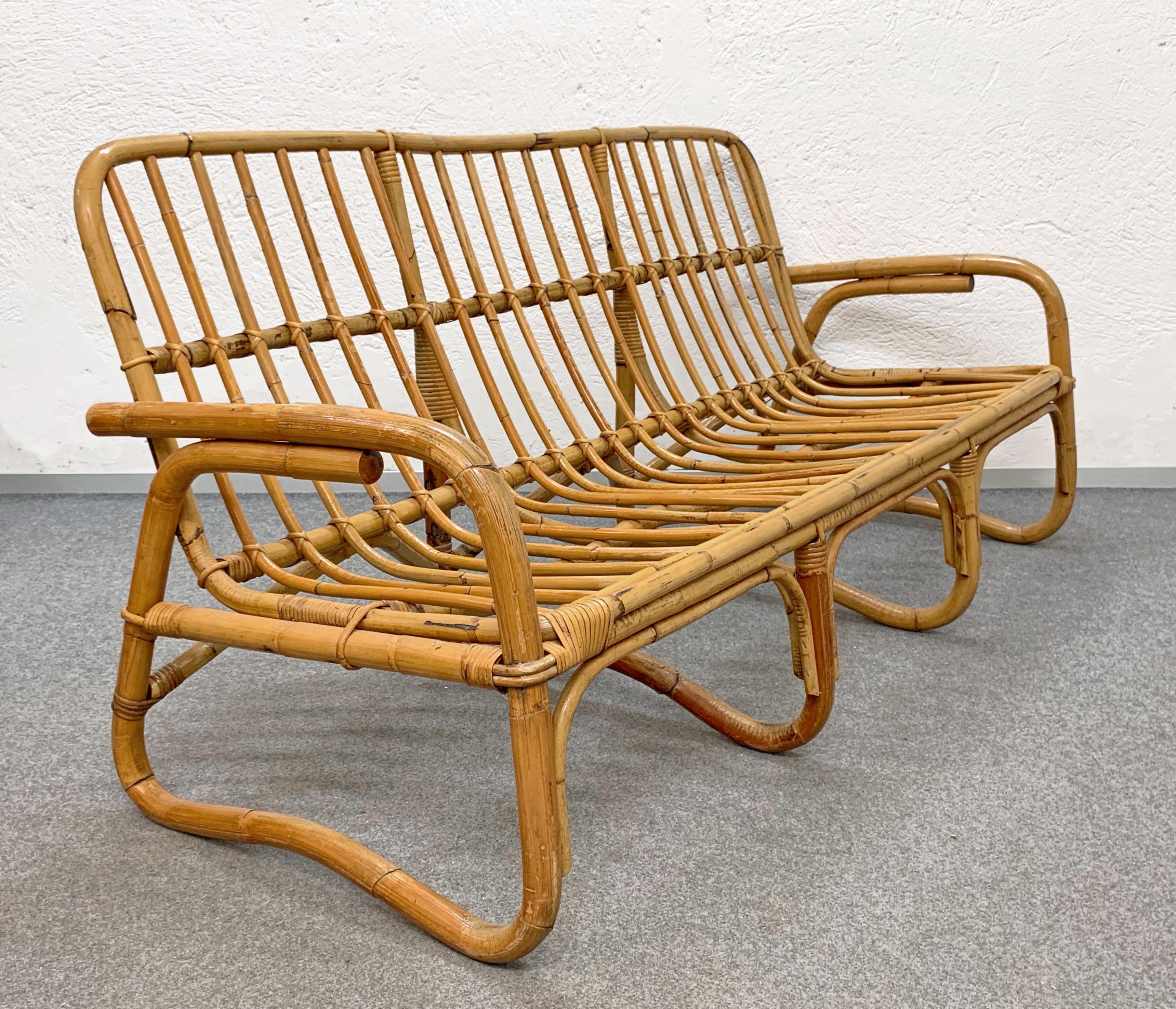 Iconic Mid-Century Modern three-seat sofa in bamboo and rattan. This amazing piece was produced in Italy during 1960s. 

This wonderful piece has a structure in curved and woven rattan and it is in good vintage conditions, with some signs of